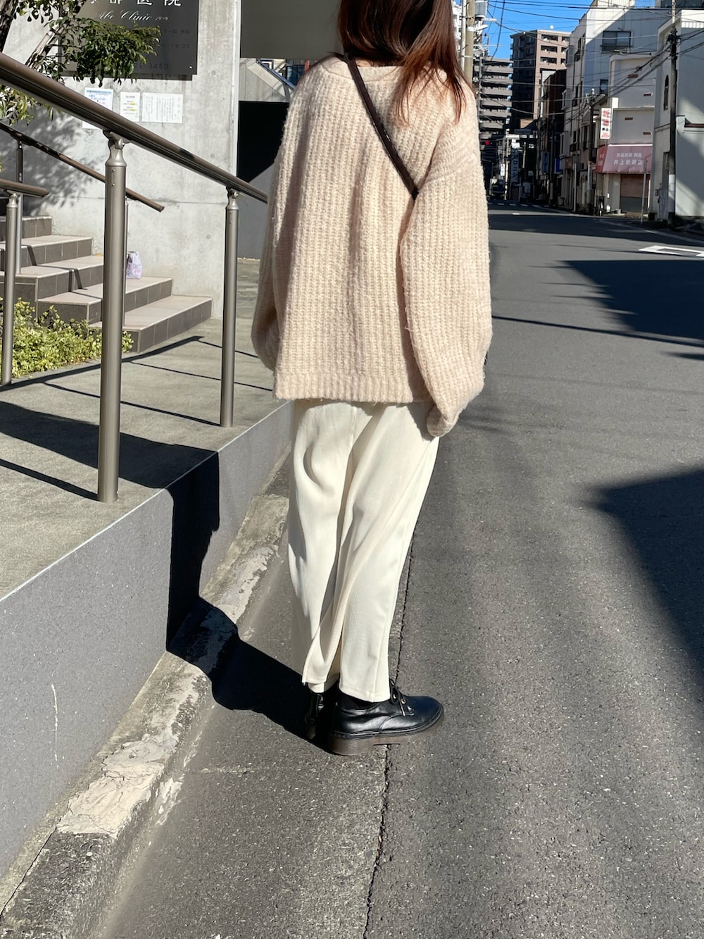 ホワイト系のニット/セーター、ホワイト系のスカートを着用したレディースの冬コーディネートの3枚目の写真