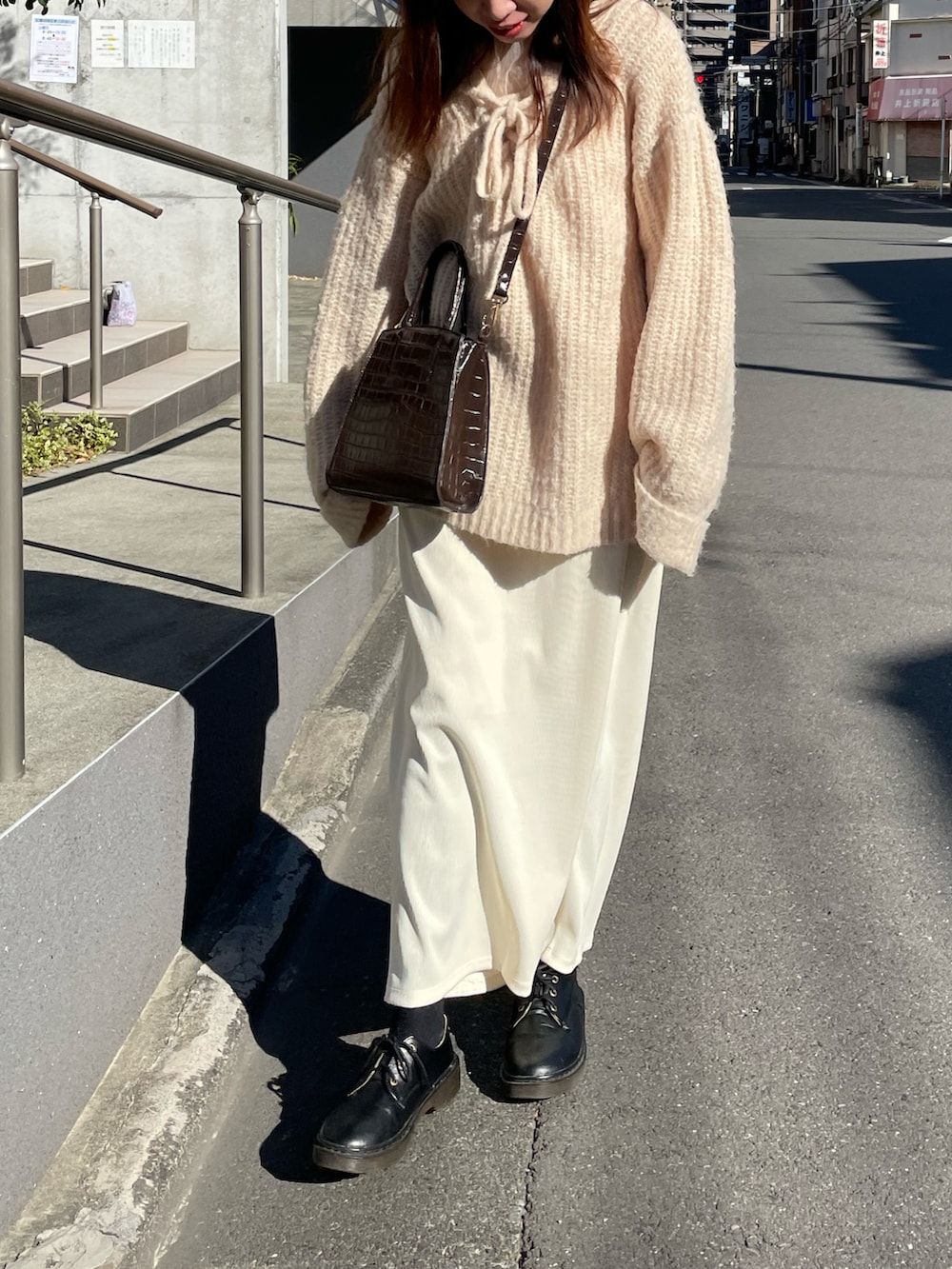 ホワイト系のニット/セーター、ホワイト系のスカートを着用したレディースの冬コーディネートの2枚目の写真