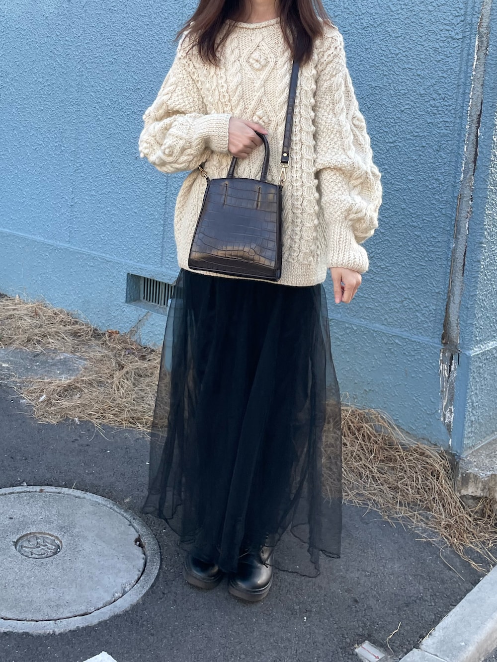 ホワイト系のニット/セーター、ブラック系のスカートを着用したレディースの冬コーディネートの4枚目の写真