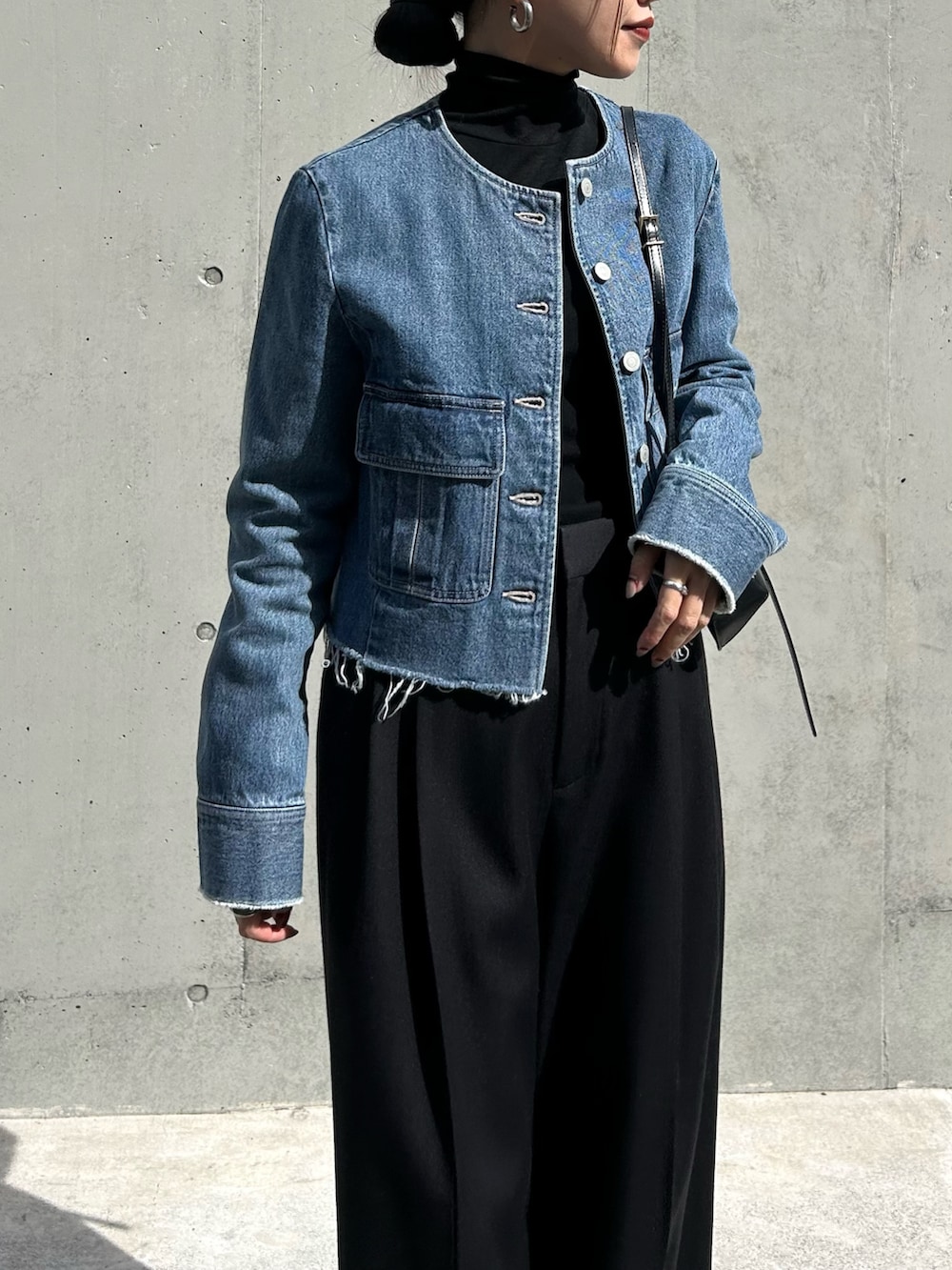 ブルー系のデニムジャケット、ブラック系のその他パンツ、ブラック系のTシャツ/カットソーを着用したレディースの秋コーディネートの2枚目の写真