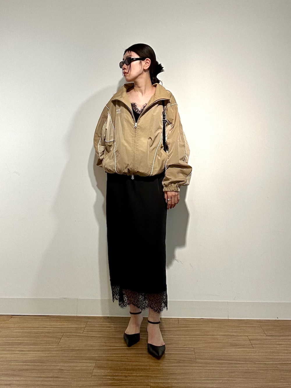 ベージュ系のブルゾン、ブラック系のキャミソール、ブラック系のパンプスを着用したレディースの冬コーディネートの2枚目の写真