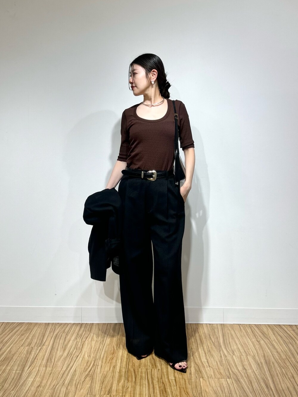 ブラウン系のTシャツ/カットソー、ブラック系のその他パンツ、ブラック系のショルダーバッグを着用したレディースの春コーディネートの2枚目の写真