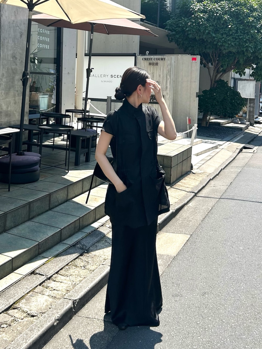 ブラック系のベストを着用したレディースの夏コーディネートの2枚目の写真