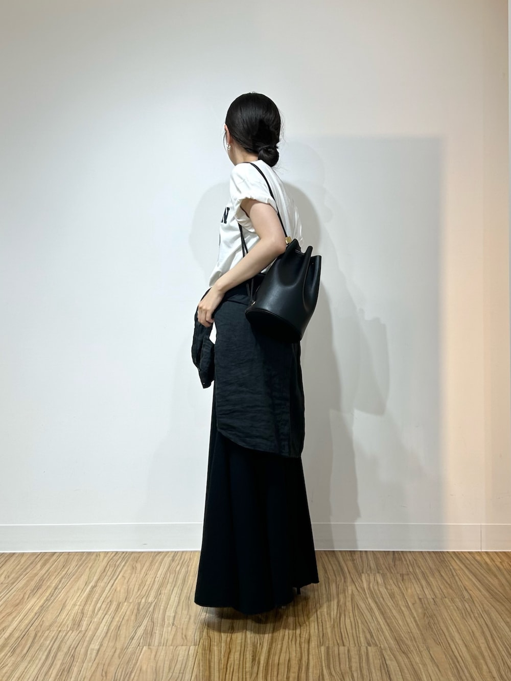 ホワイト系のTシャツ/カットソー、ブラック系のシャツ/ブラウス、ブラック系のスカートを着用したレディースの春コーディネートの2枚目の写真