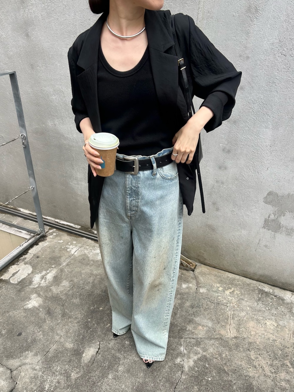 ブラック系のテーラードジャケット、ブルー系のデニムパンツ、ブラック系のサンダルを着用したレディースの夏コーディネートの2枚目の写真