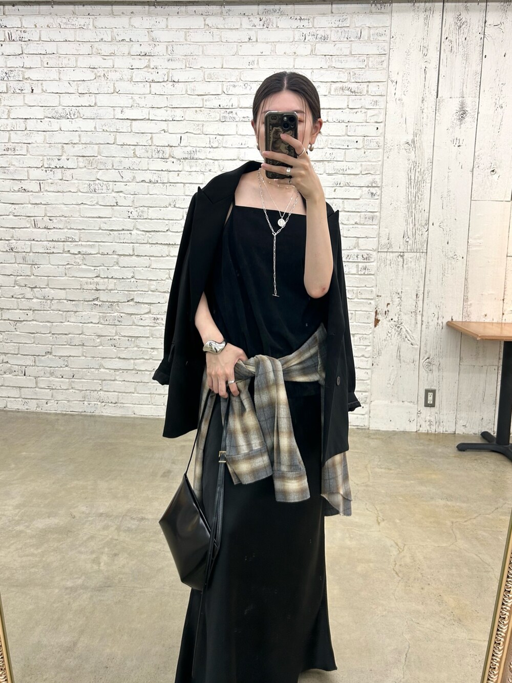 ブラック系のテーラードジャケット、グレー系のシャツ/ブラウス、ブラック系のブーツを着用したレディースの秋コーディネートの2枚目の写真