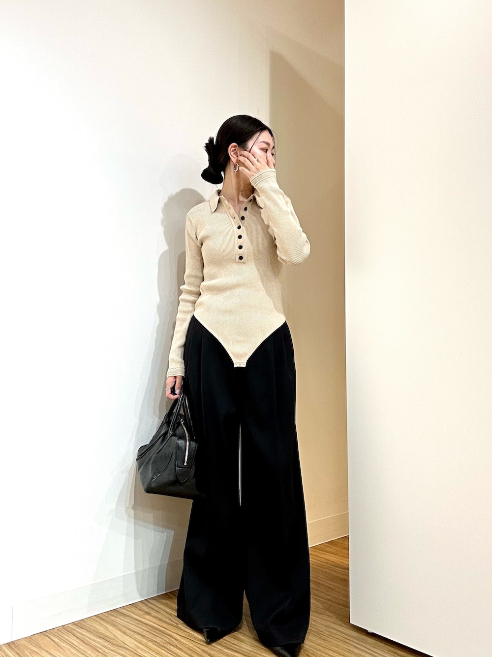 ベージュ系のニット/セーター、ブラック系のその他パンツ、ブラック系のトートバッグを着用したレディースの冬コーディネートの2枚目の写真