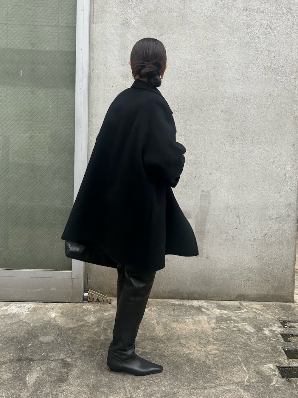 ブラック系のピーコート、ブラック系のブーツ、グレー系のスウェットを着用したレディースの秋コーディネートの2枚目の写真