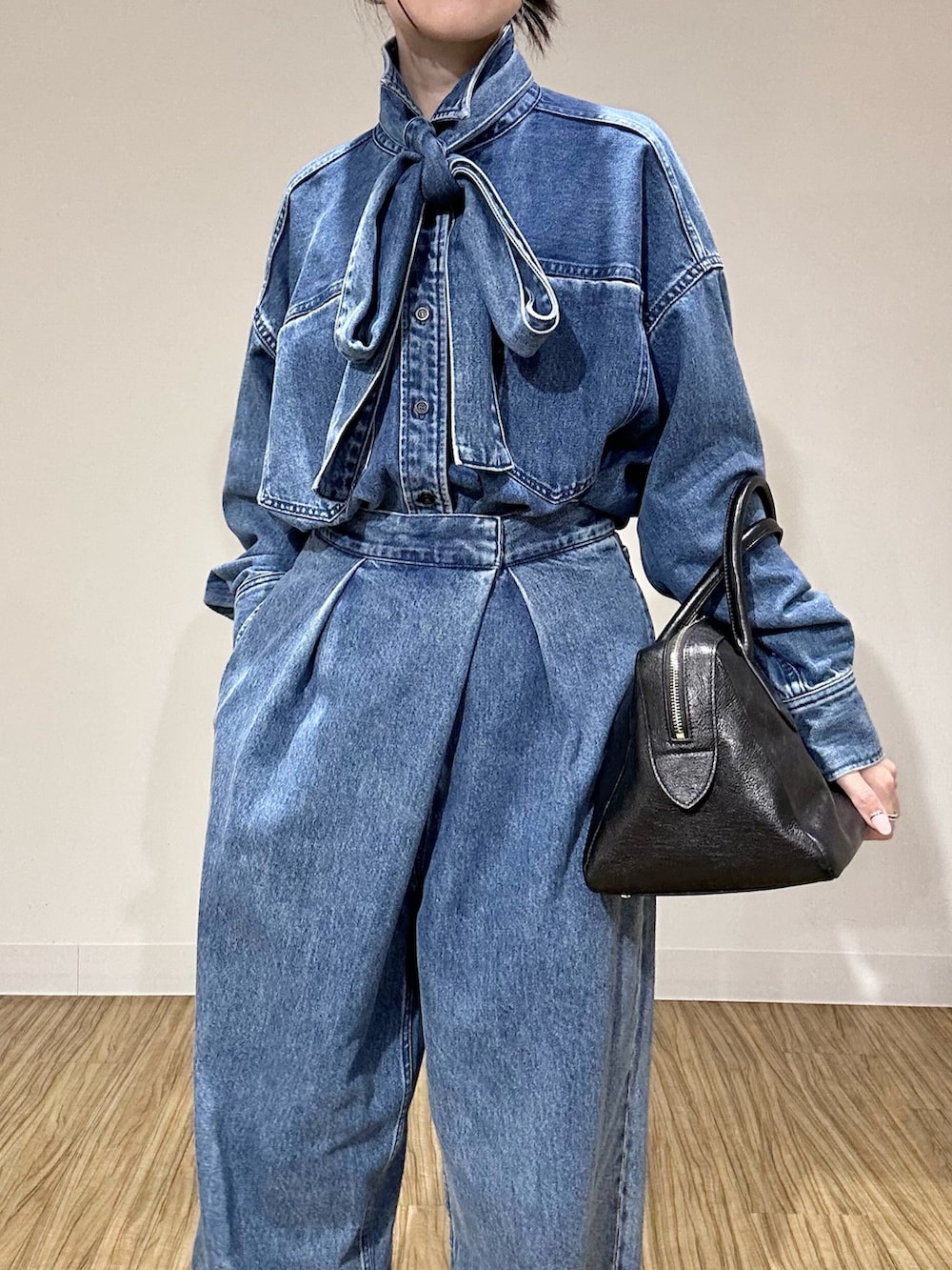 ブルー系のシャツ/ブラウス、ブラック系のトートバッグ、ブルー系のデニムパンツを着用したレディースの夏コーディネートの3枚目の写真