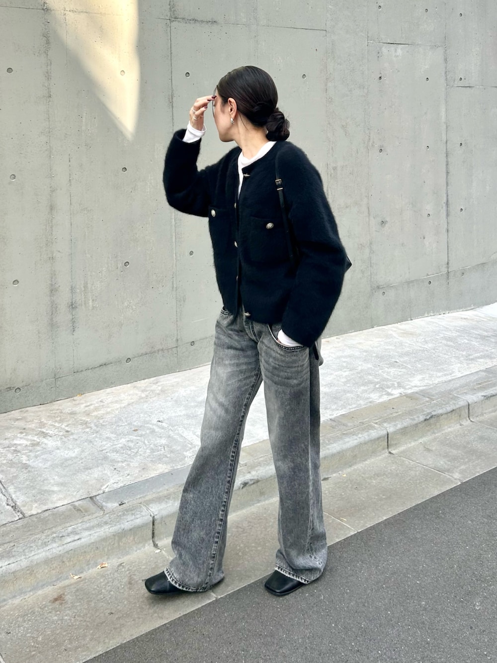 ブラック系のカーディガン/ボレロ、ホワイト系のTシャツ/カットソー、グレー系のデニムパンツを着用したレディースの秋コーディネートの3枚目の写真