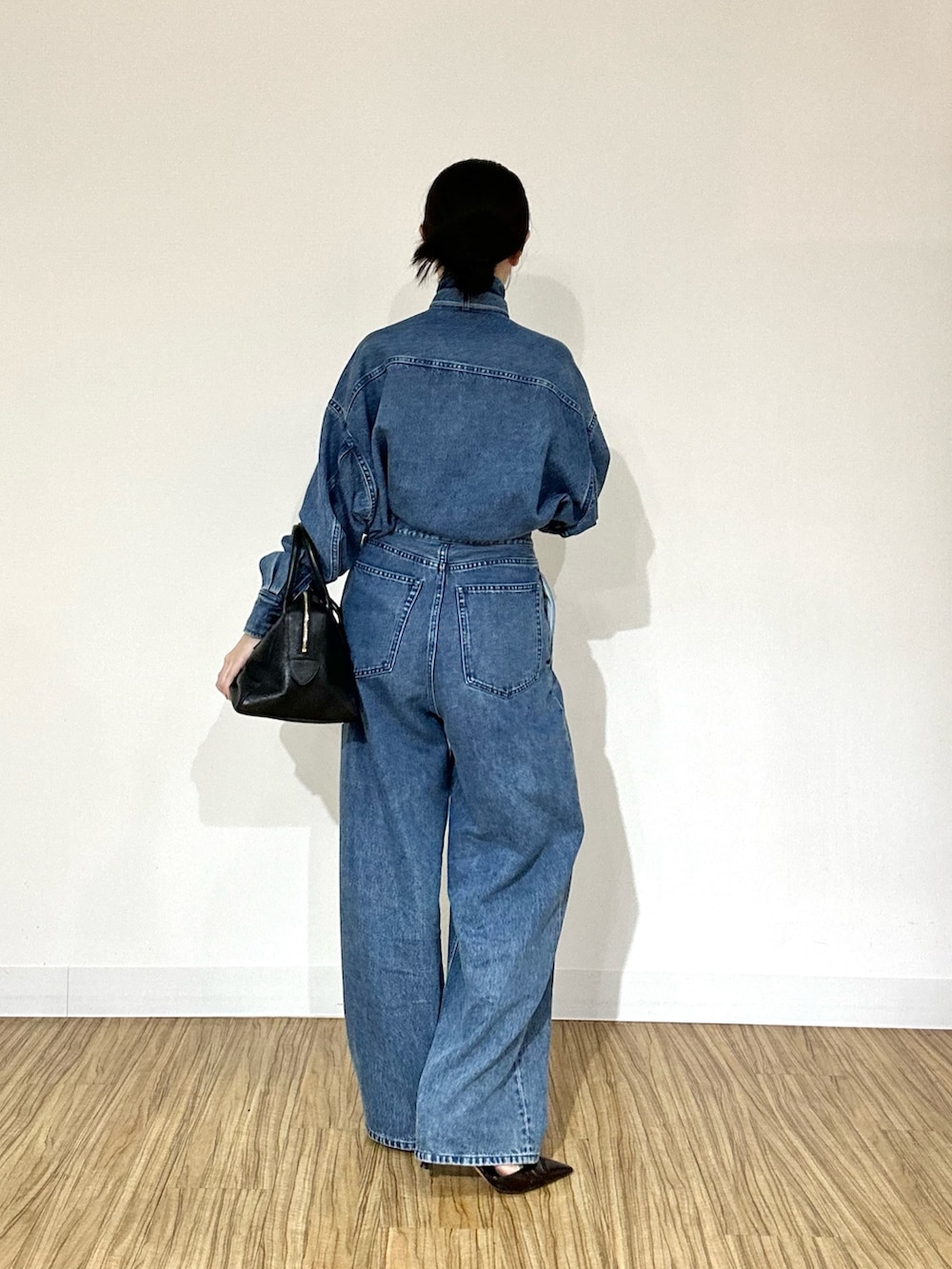 ブルー系のシャツ/ブラウス、ブラック系のトートバッグ、ブルー系のデニムパンツを着用したレディースの夏コーディネートの2枚目の写真