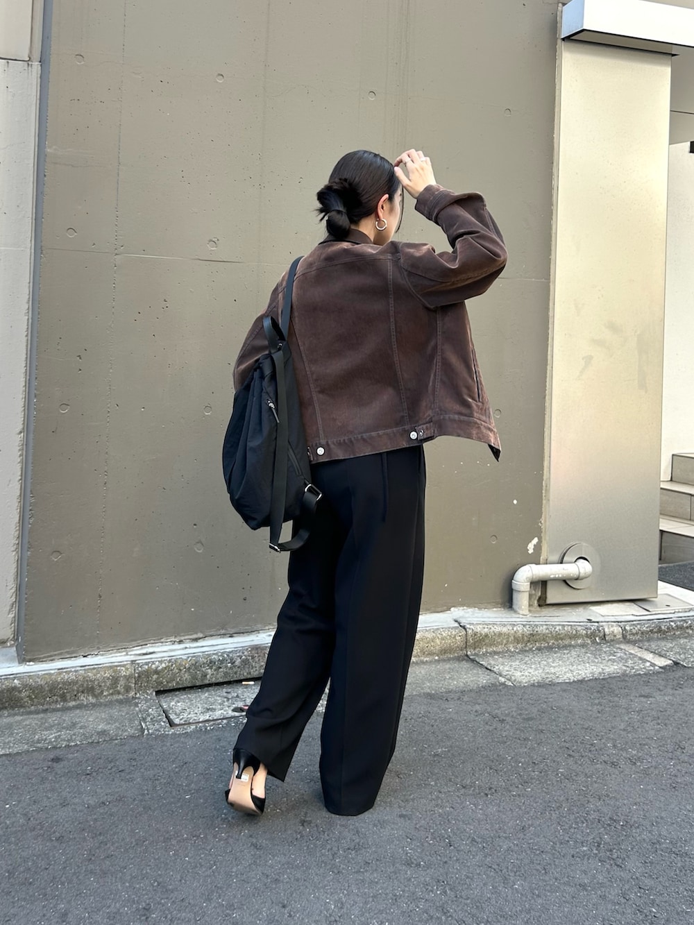 ブラック系のバックパック/リュック、ブラウン系のその他パンツ、ブラウン系のデニムジャケットを着用したレディースの秋コーディネートの2枚目の写真