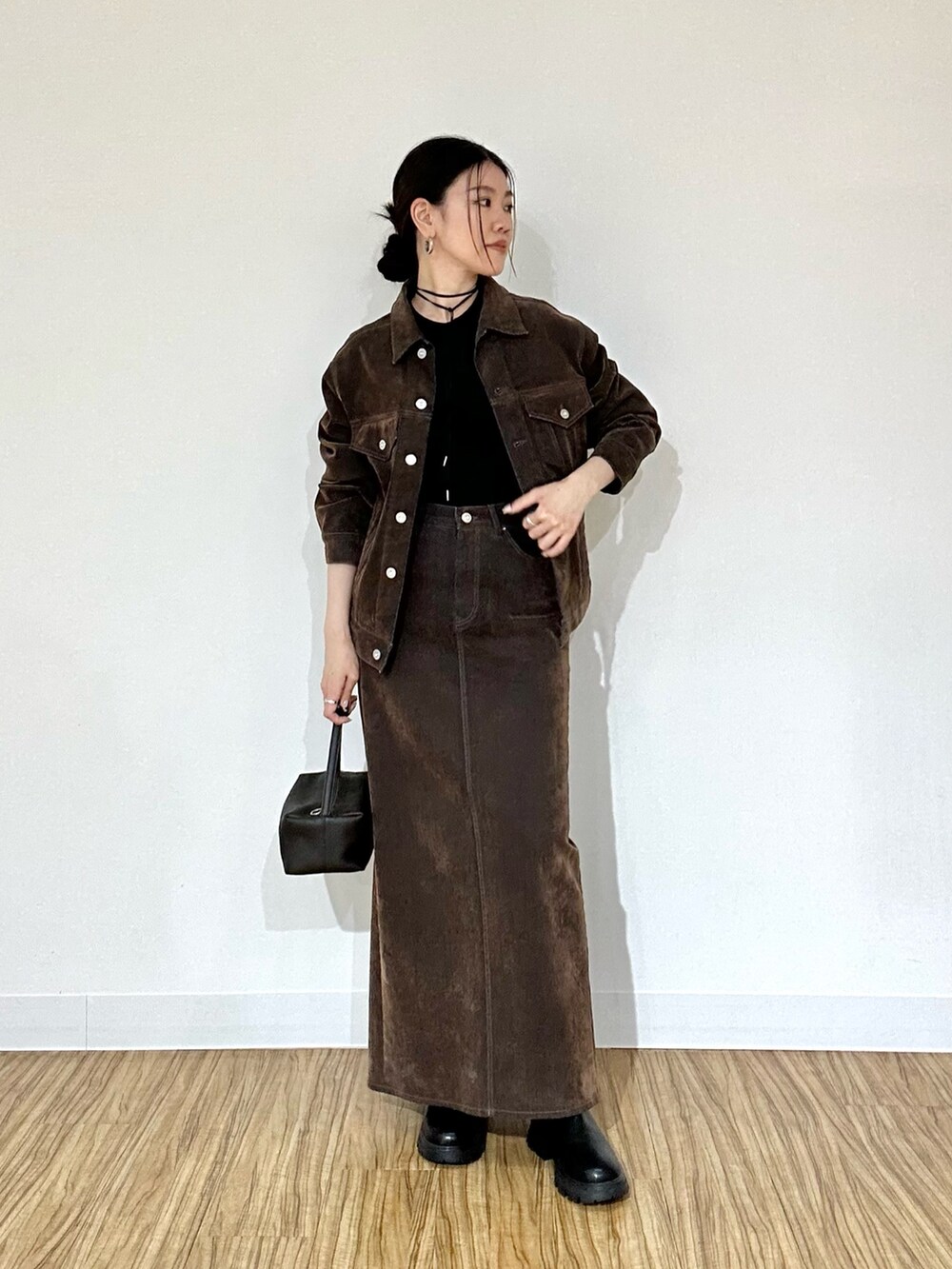 ブラウン系のデニムジャケット、ブラック系のTシャツ/カットソー、ブラウン系のデニムスカートを着用したレディースの夏コーディネートの2枚目の写真