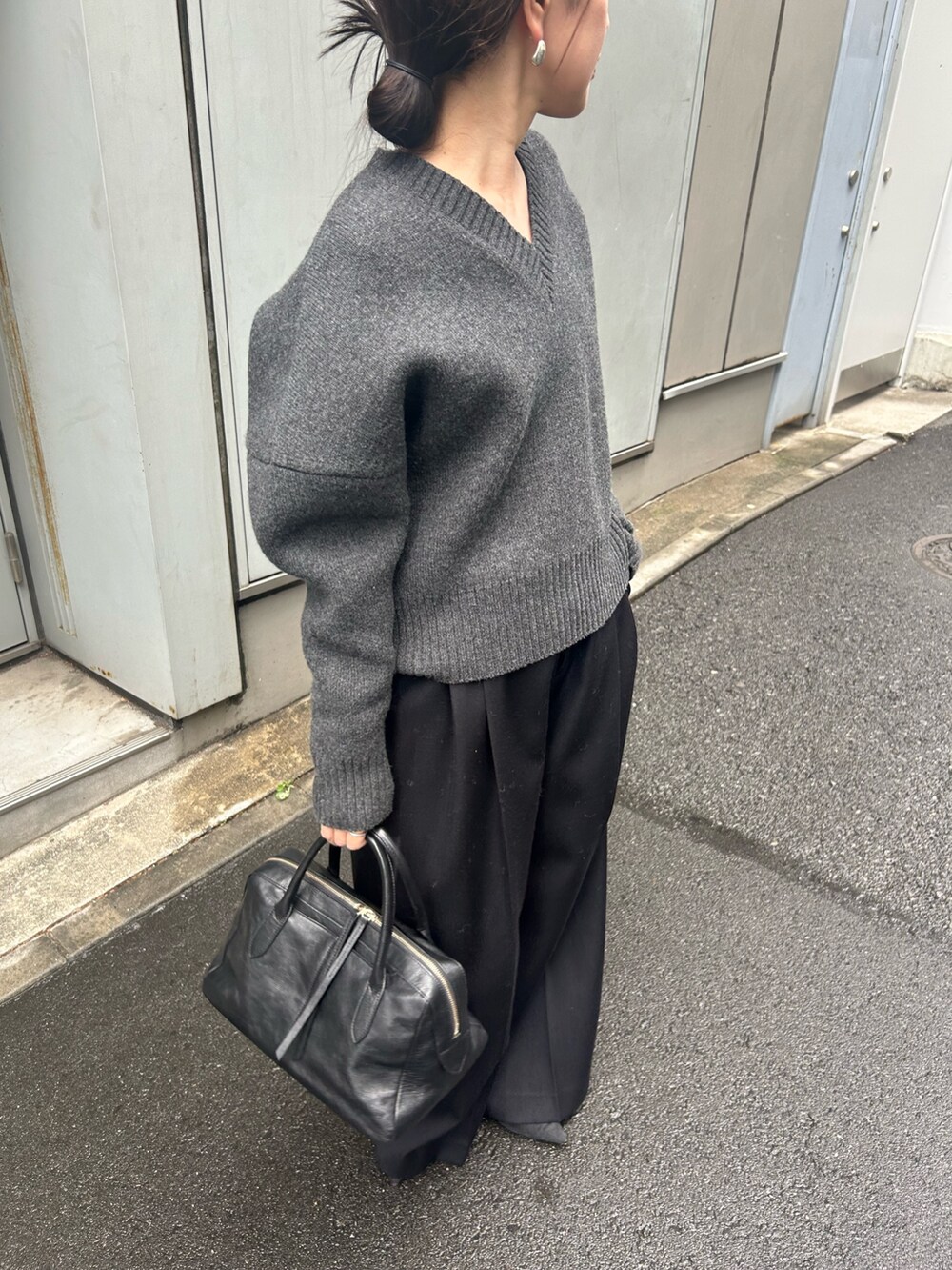 グレー系のニット/セーター、ブラック系のその他パンツ、ブラック系のトートバッグを着用したレディースの秋コーディネートの2枚目の写真