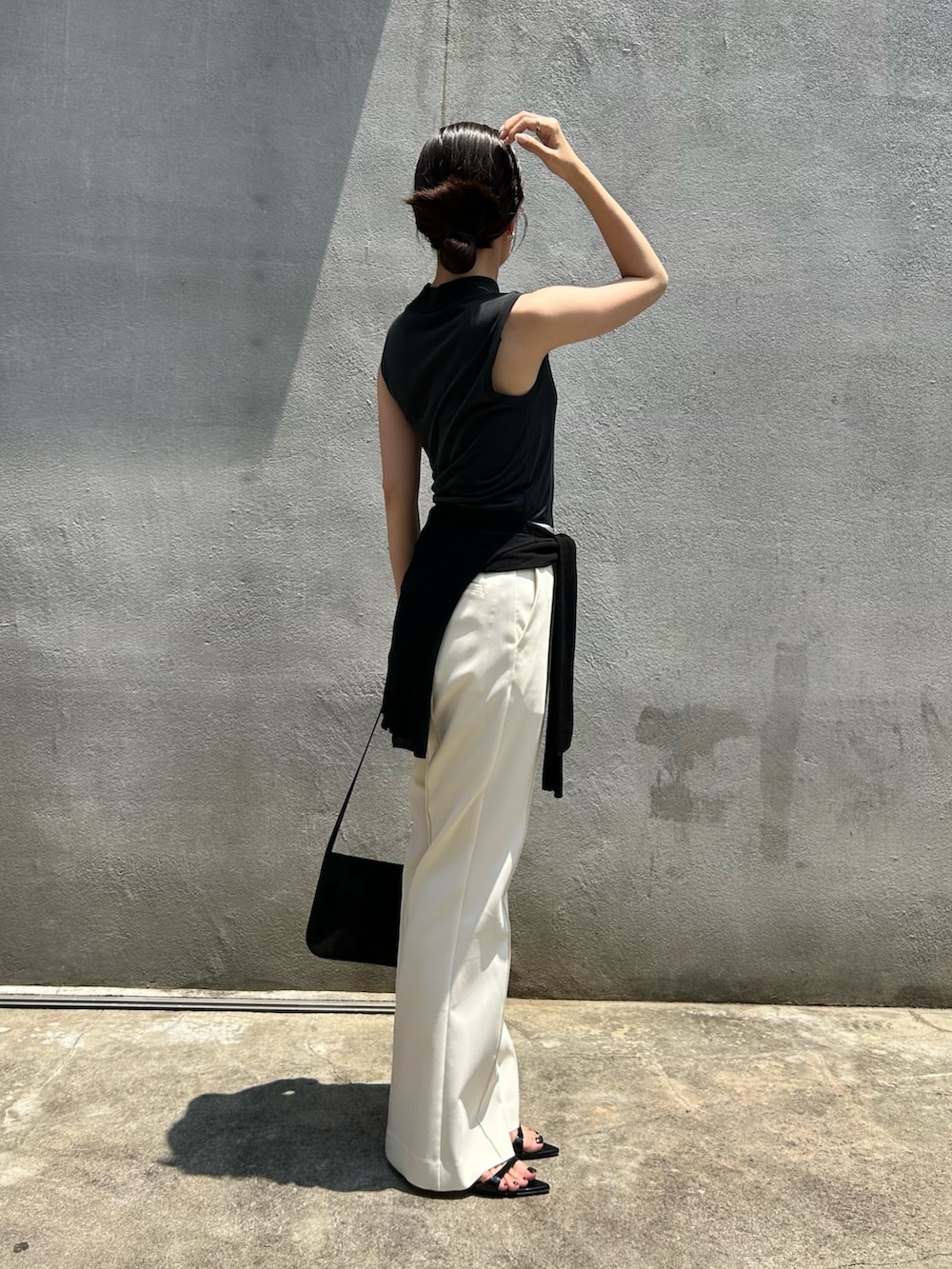 ブラック系のTシャツ/カットソー、ブラック系のショルダーバッグ、ホワイト系のその他パンツを着用したレディースの夏コーディネートの2枚目の写真