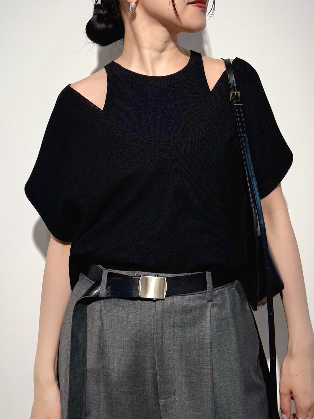 ブラック系のニット/セーター、グレー系のその他パンツ、ブラック系のショルダーバッグを着用したレディースの夏コーディネートの2枚目の写真