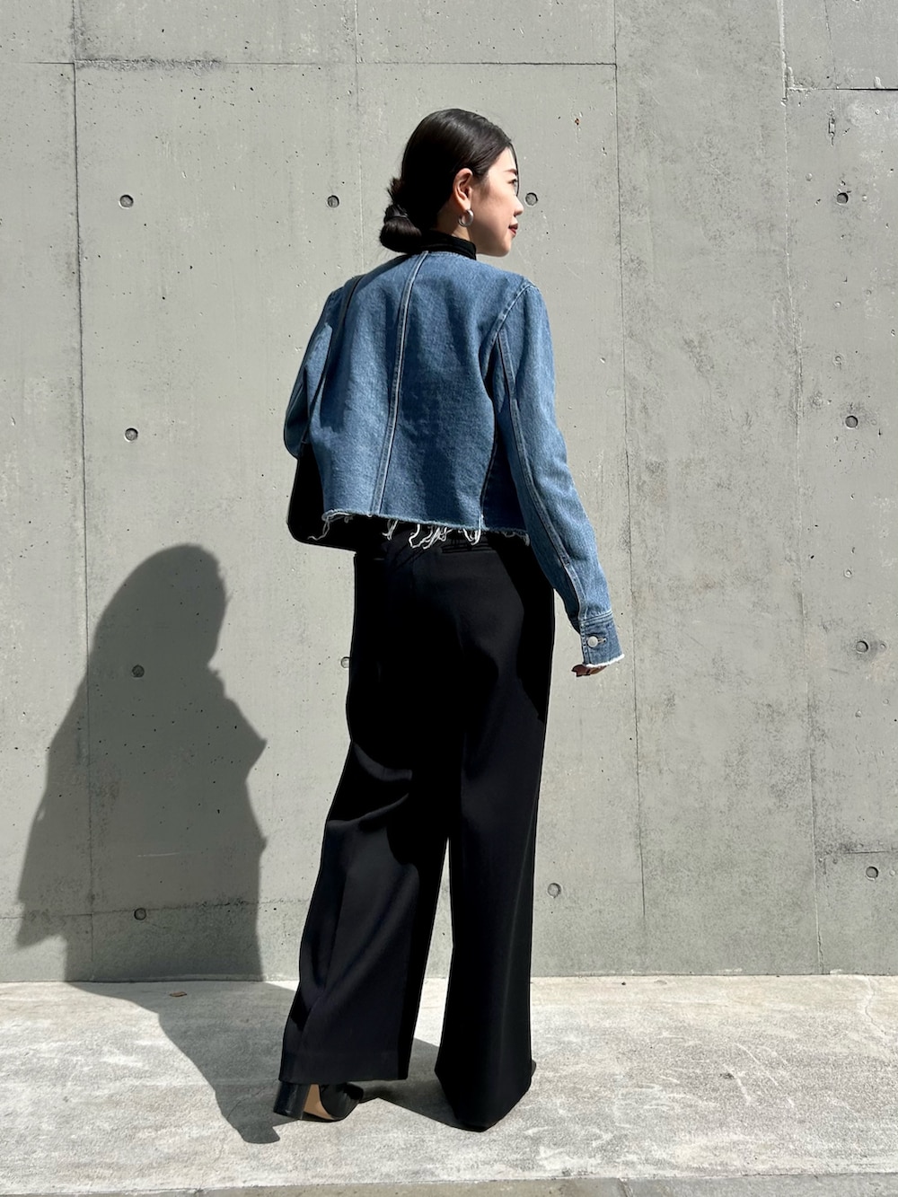 ブルー系のデニムジャケット、ブラック系のその他パンツ、ブラック系のTシャツ/カットソーを着用したレディースの秋コーディネートの3枚目の写真