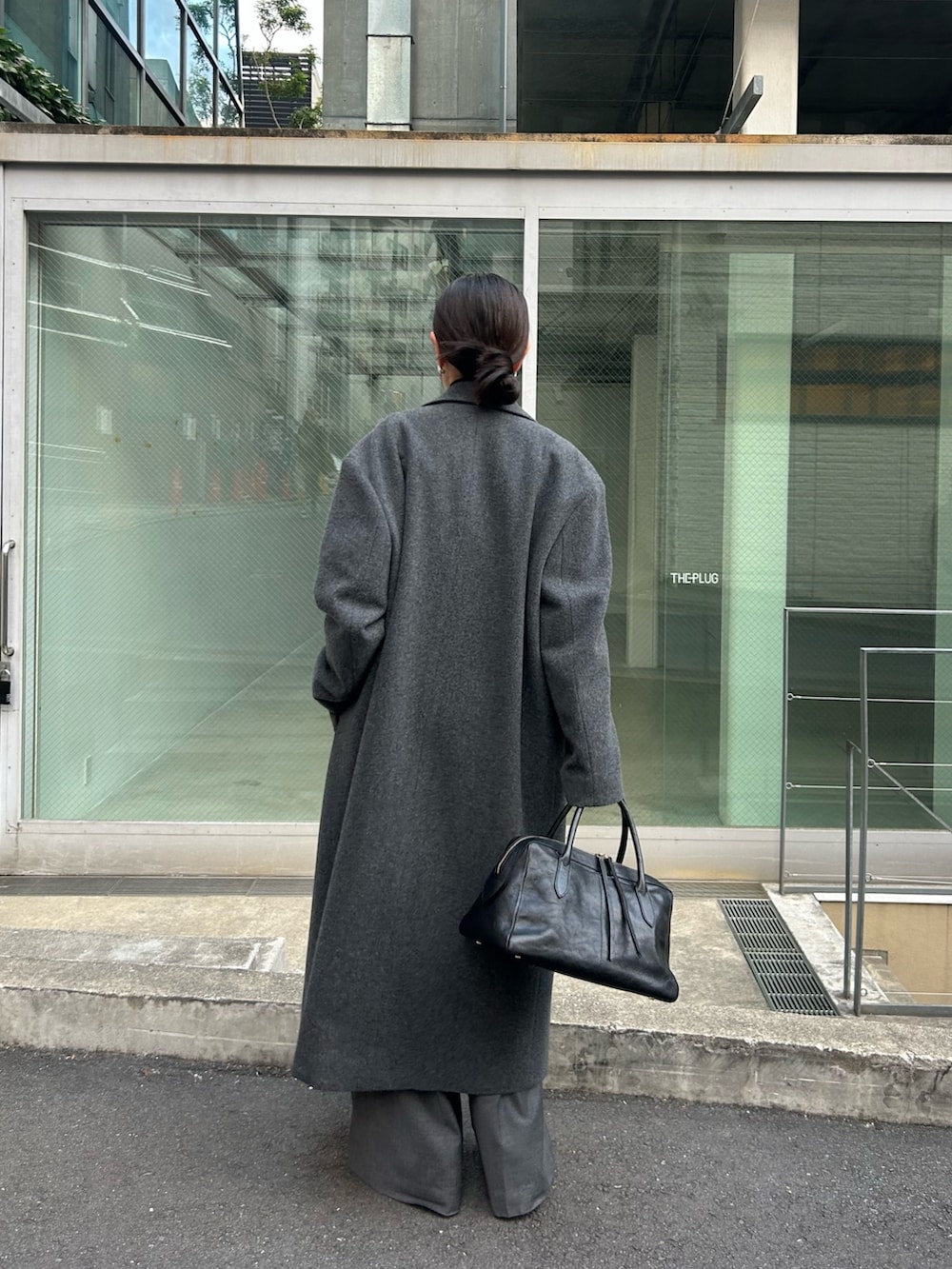 グレー系のチェスターコート、ブラック系のTシャツ/カットソー、グレー系のその他パンツを着用したレディースの秋コーディネートの2枚目の写真