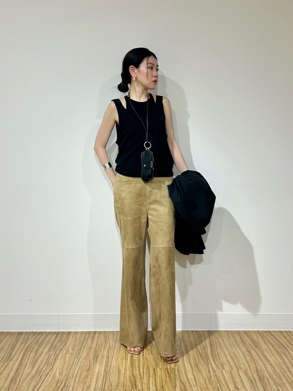 ブラック系のテーラードジャケット、イエロー系のその他パンツ、ブラック系のカーディガン/ボレロを着用したレディースの春コーディネートの2枚目の写真
