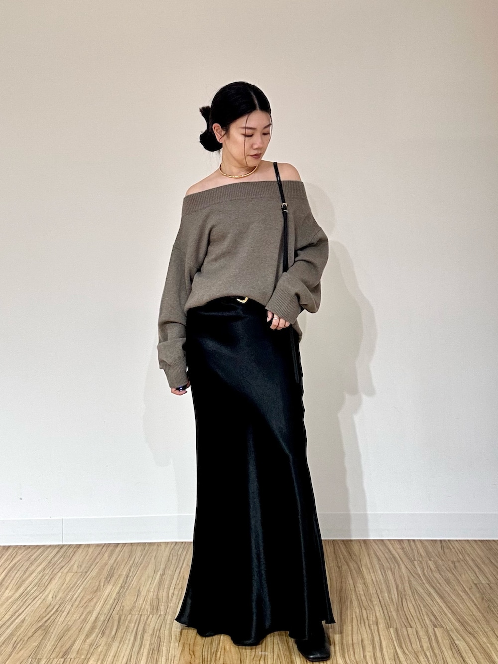 ブラウン系のニット/セーター、ブラック系のショルダーバッグ、ブラック系のブーツを着用したレディースの秋コーディネートの2枚目の写真