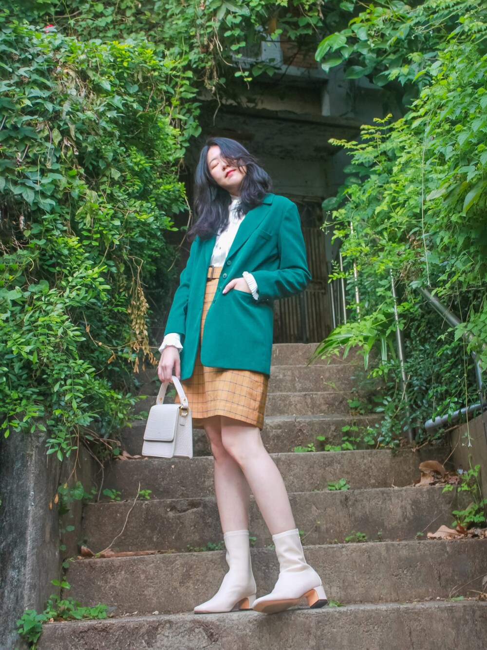 グリーン系のテーラードジャケット、イエロー系のスカート、ホワイト系のトップスを着用したレディースの冬コーディネートの2枚目の写真