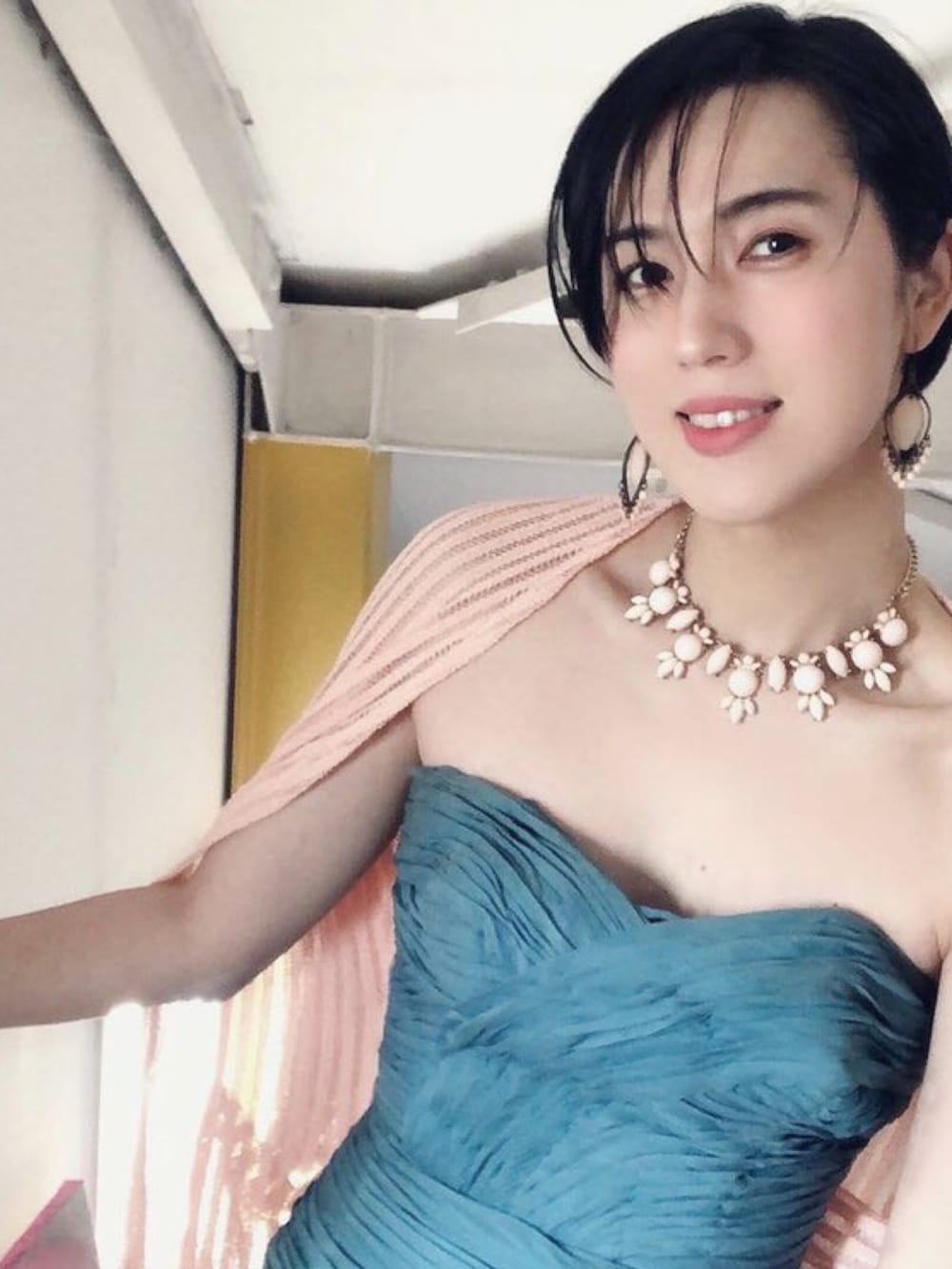 イエロー系のパンツ、ブラック系のスウェット、ブラック系のパンプスを着用したレディースの冬コーディネートの2枚目の写真