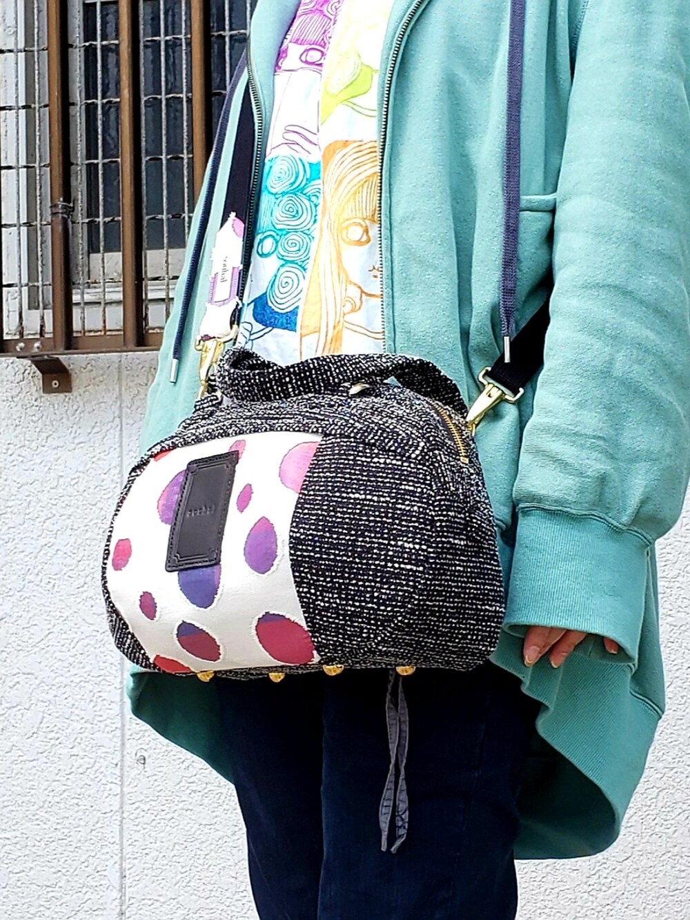 グリーン系のブルゾン、ホワイト系のTシャツ/カットソー、ブラック系のショルダーバッグを着用したレディースの春コーディネートの4枚目の写真