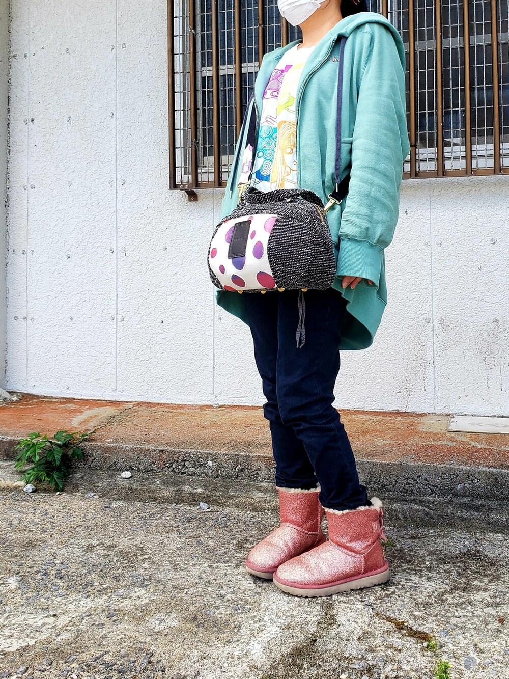 グリーン系のブルゾン、ホワイト系のTシャツ/カットソー、ブラック系のショルダーバッグを着用したレディースの春コーディネートの2枚目の写真