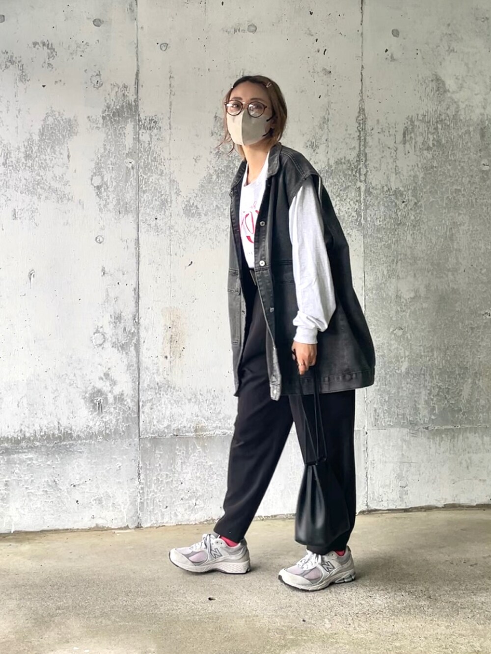 ベージュ系のTシャツ/カットソー、ブラック系のベスト、ブラック系のスラックスを着用したレディースの春コーディネートの2枚目の写真