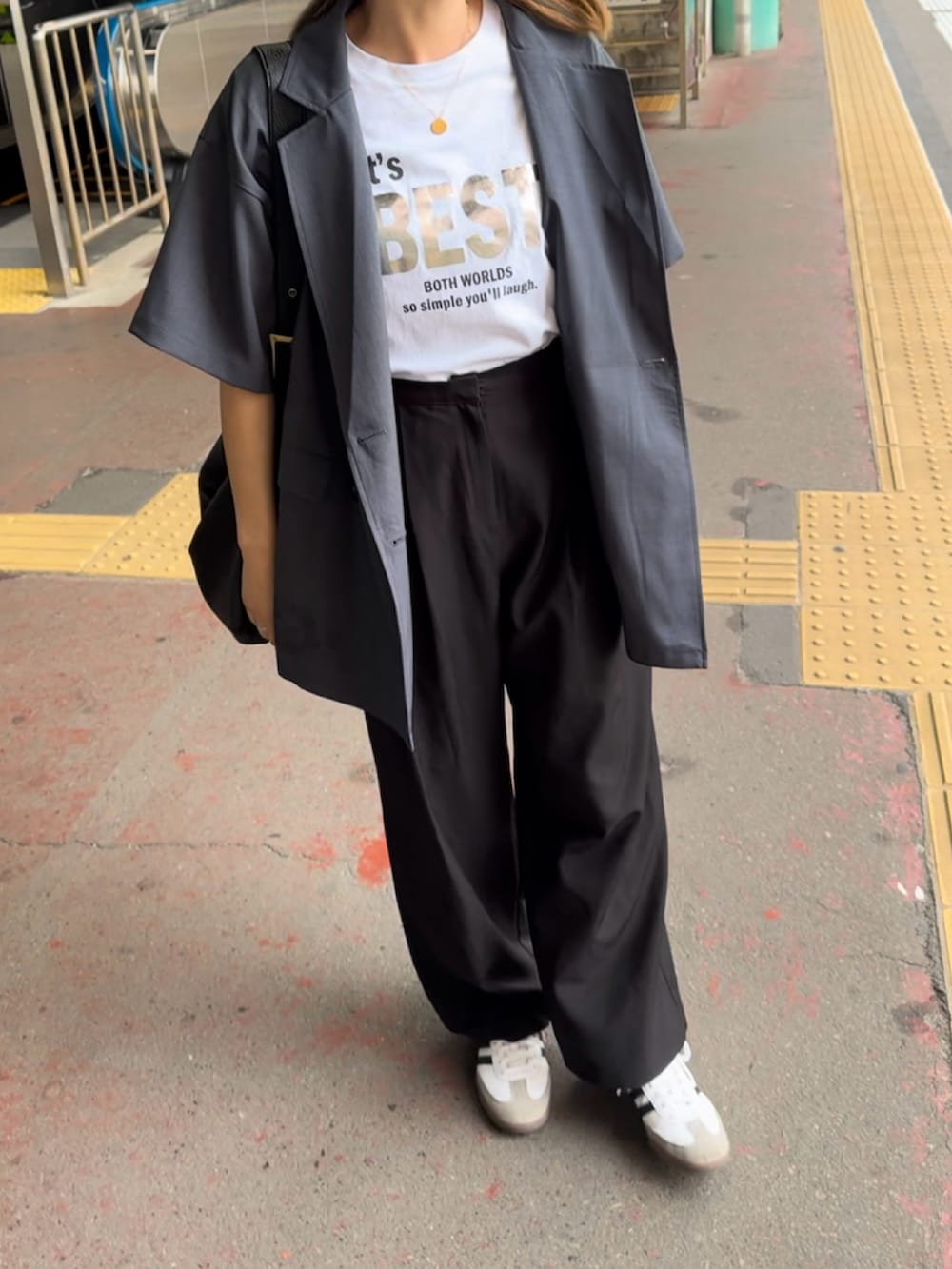 グレー系のテーラードジャケット、ホワイト系のスニーカー、ホワイト系のTシャツ/カットソーを着用したレディースの夏コーディネートの3枚目の写真