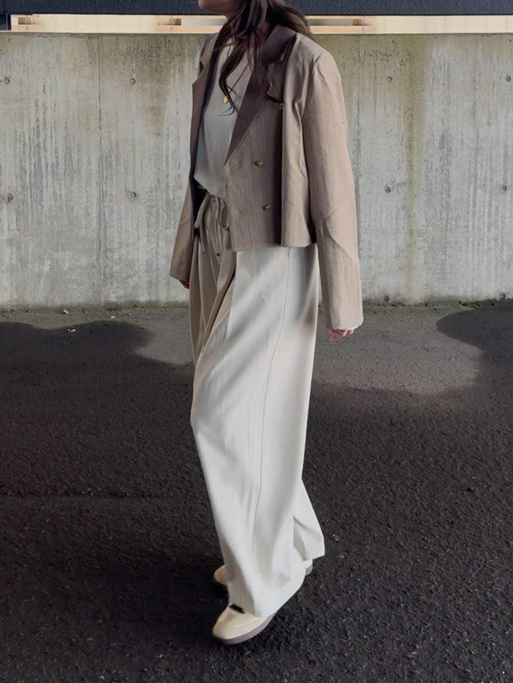 ホワイト系のTシャツ/カットソー、ベージュ系のテーラードジャケット、ホワイト系のスラックスを着用したレディースの春コーディネートの4枚目の写真
