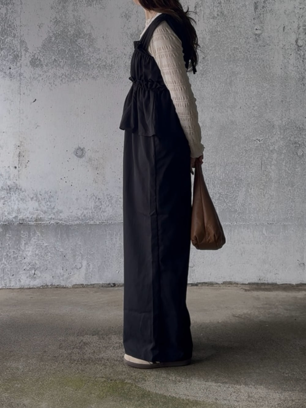 ベージュ系のTシャツ/カットソー、ブラック系のサロペット/オーバーオール、ベージュ系のスニーカーを着用したレディースの冬コーディネートの4枚目の写真