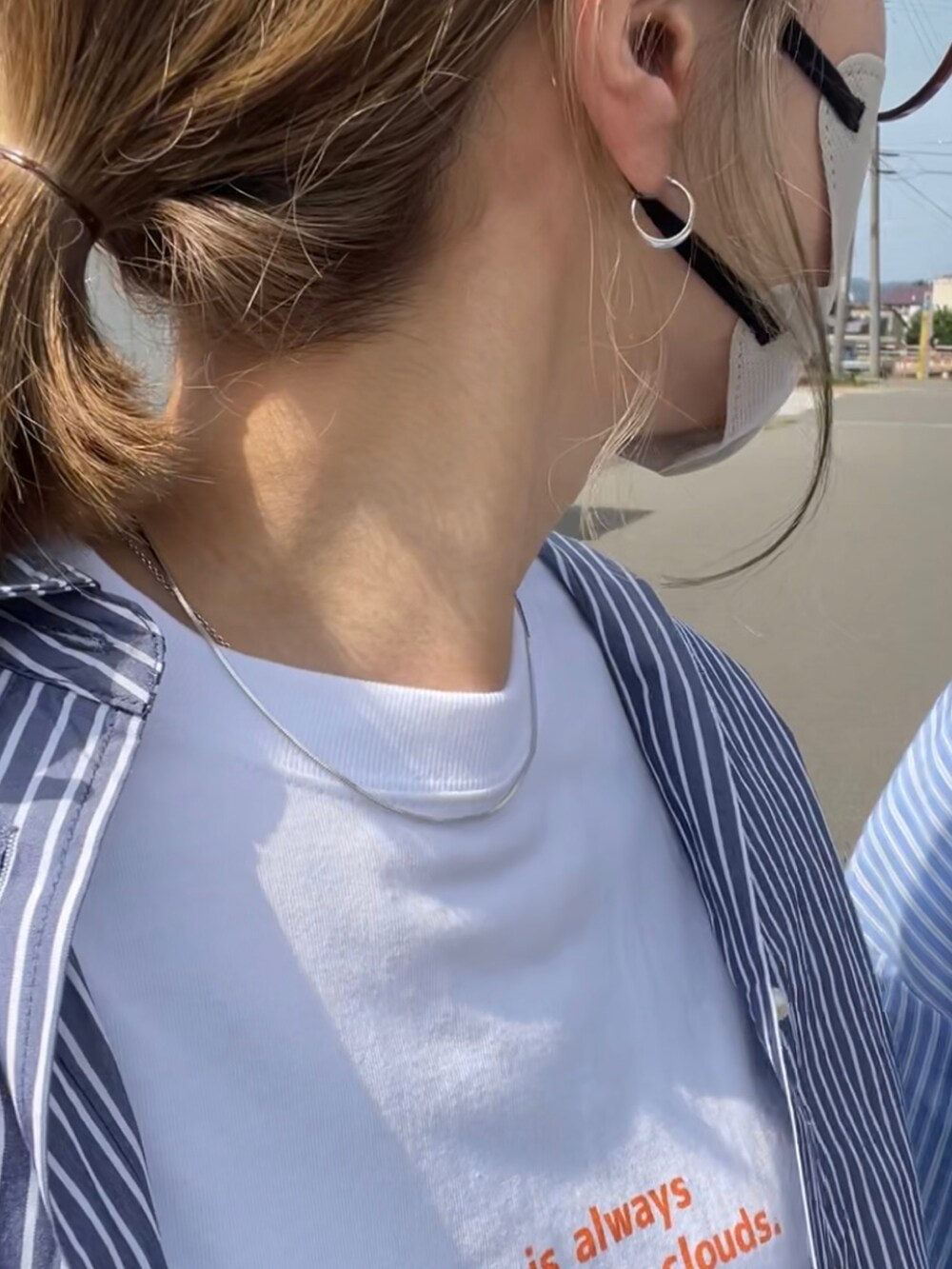 オレンジ系のTシャツ/カットソー、ベージュ系のチノパンツ、ブルー系のシャツ/ブラウスを着用したレディースの夏コーディネートの3枚目の写真