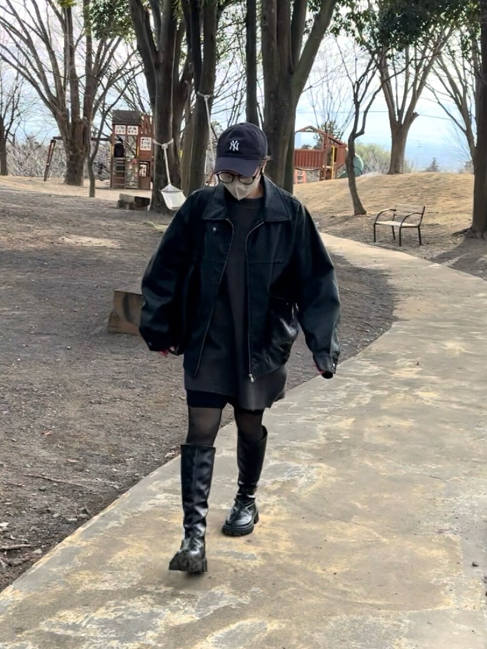 ブラック系のブルゾン、ブラック系のブーツ、グレー系のニット/セーターを着用したレディースの冬コーディネートの2枚目の写真