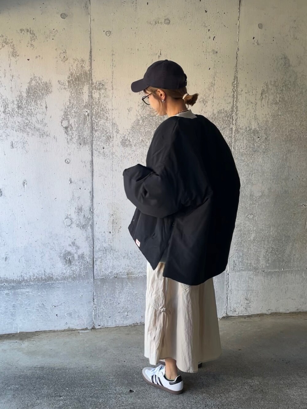 ブラック系のノーカラージャケット、ホワイト系のスカート、ホワイト系のスニーカーを着用したレディースの秋コーディネートの3枚目の写真