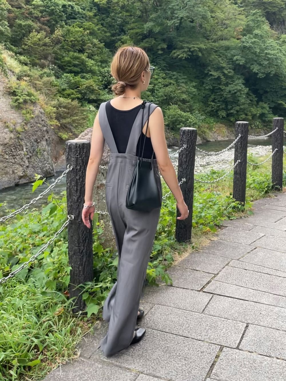 グレー系のサロペット/オーバーオール、ブラック系のパンプス、ブラック系のショルダーバッグを着用したレディースの夏コーディネートの2枚目の写真