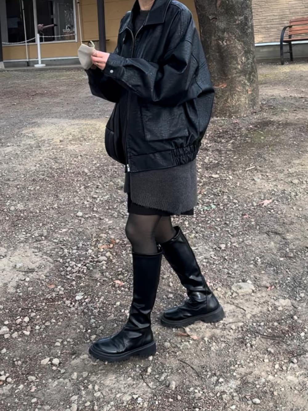 ブラック系のブルゾン、ブラック系のブーツ、グレー系のニット/セーターを着用したレディースの冬コーディネートの3枚目の写真