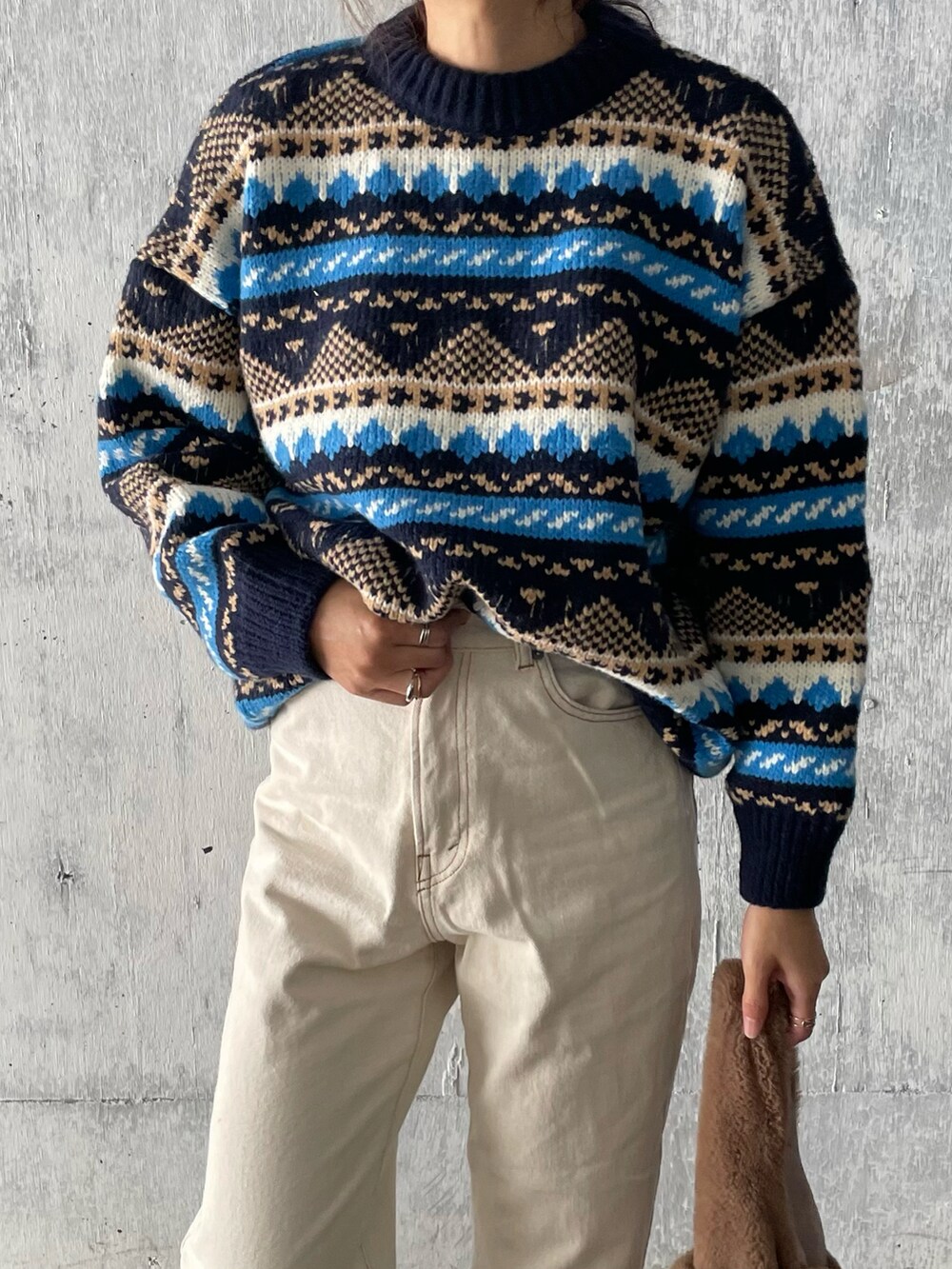 ホワイト系のデニムパンツ、ブラック系のブーツ、その他のニット/セーターを着用したレディースの冬コーディネートの2枚目の写真