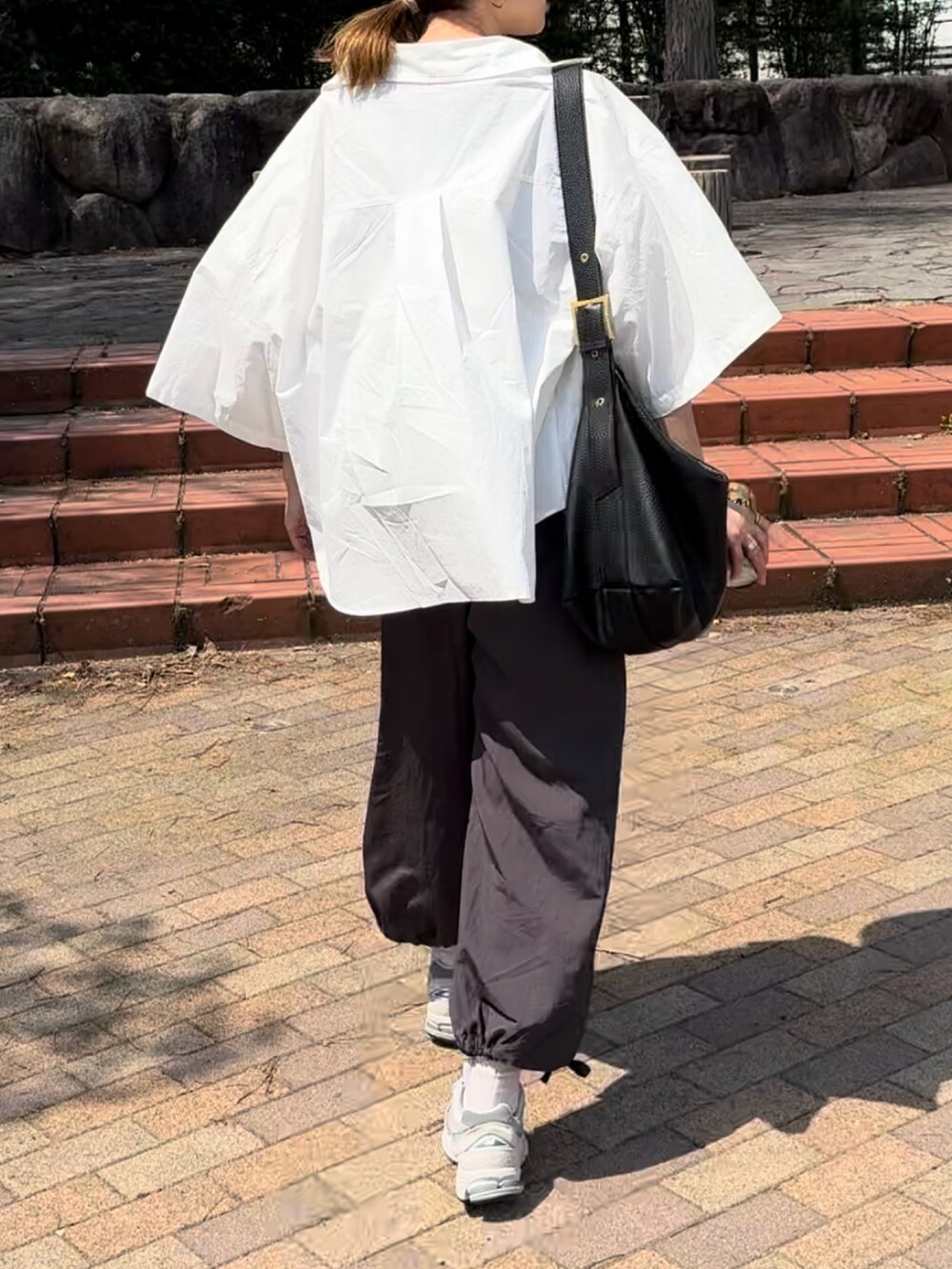 ホワイト系のシャツ/ブラウス、グレー系のその他パンツ、グレー系のスニーカーを着用したレディースの春コーディネートの3枚目の写真