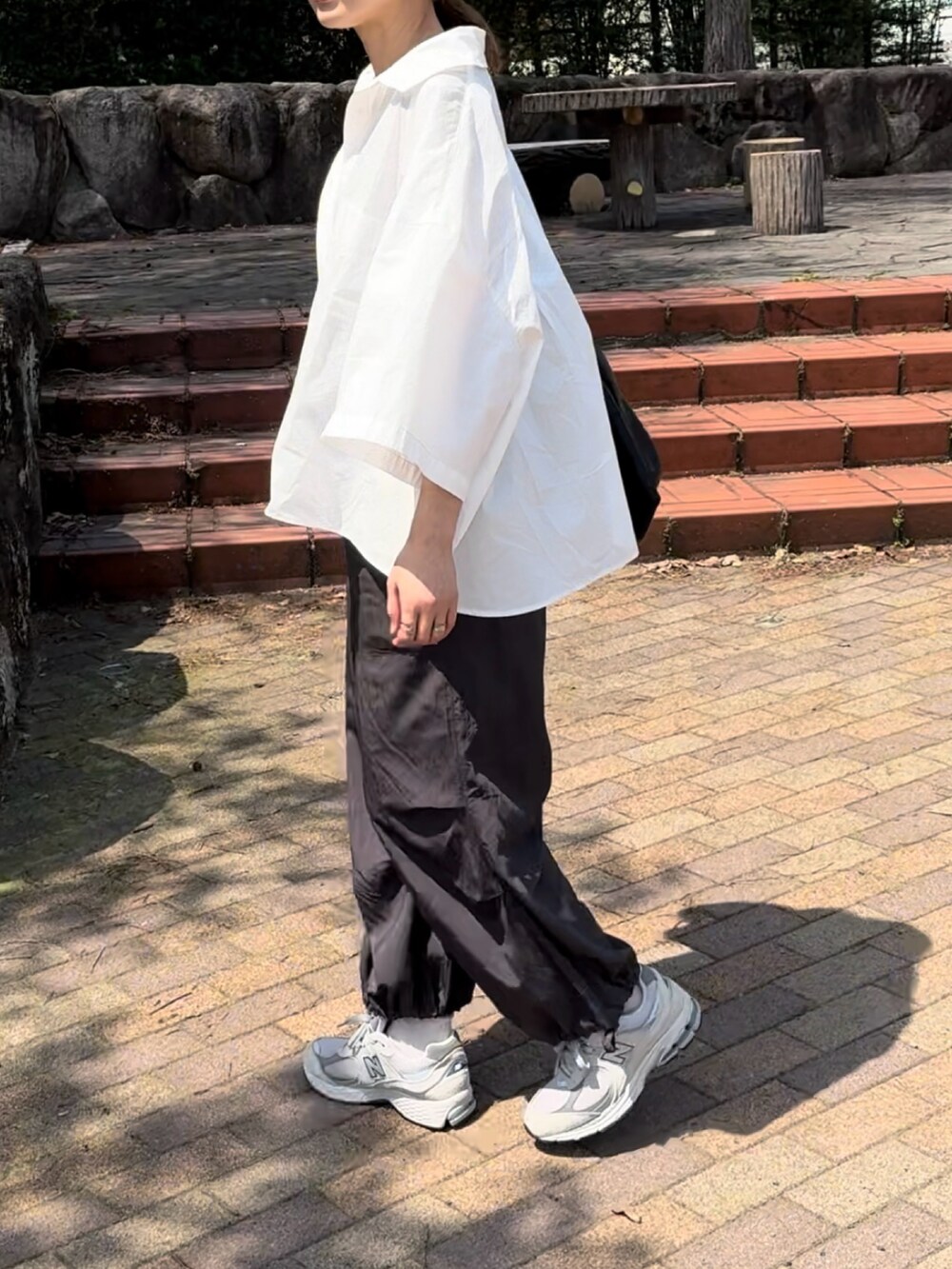 ホワイト系のシャツ/ブラウス、グレー系のその他パンツ、グレー系のスニーカーを着用したレディースの春コーディネートの2枚目の写真