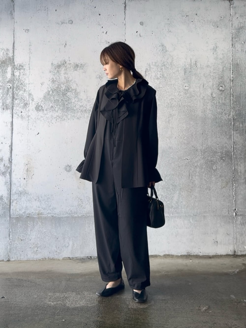 ブラック系のつなぎ/オールインワン、ブラック系のベスト、ブラック系のパンプスを着用したレディースの春コーディネートの2枚目の写真