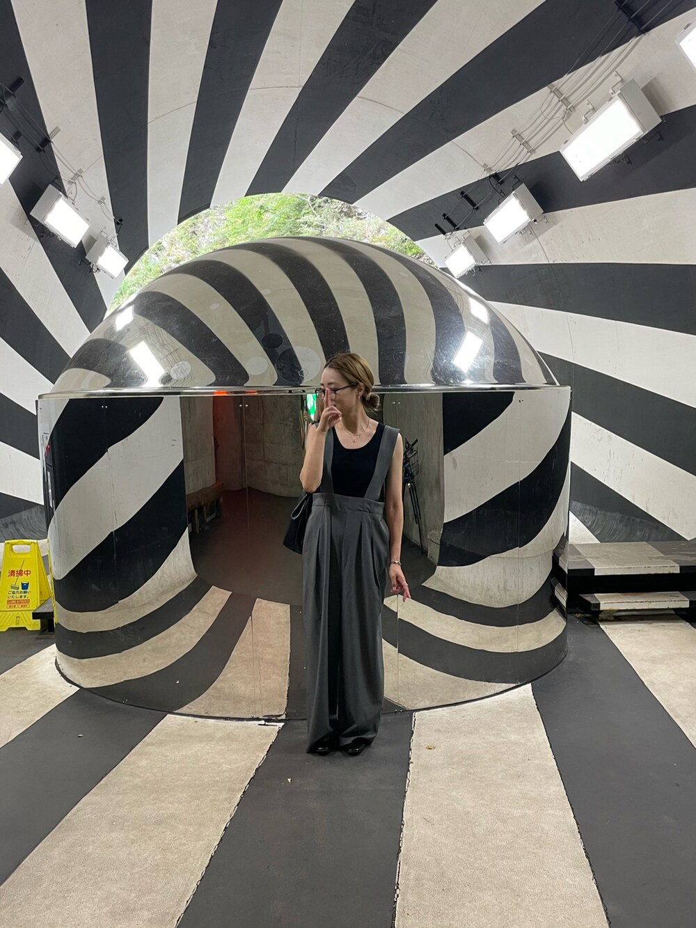 グレー系のサロペット/オーバーオール、ブラック系のパンプス、ブラック系のショルダーバッグを着用したレディースの夏コーディネートの3枚目の写真