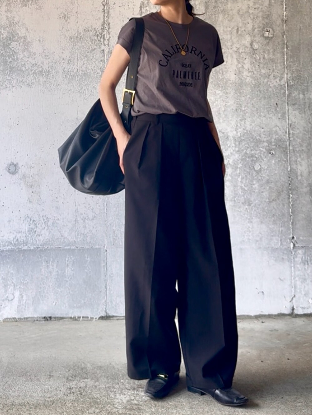 グレー系のTシャツ/カットソー、ブラック系のスラックスを着用したレディースの夏コーディネートの2枚目の写真
