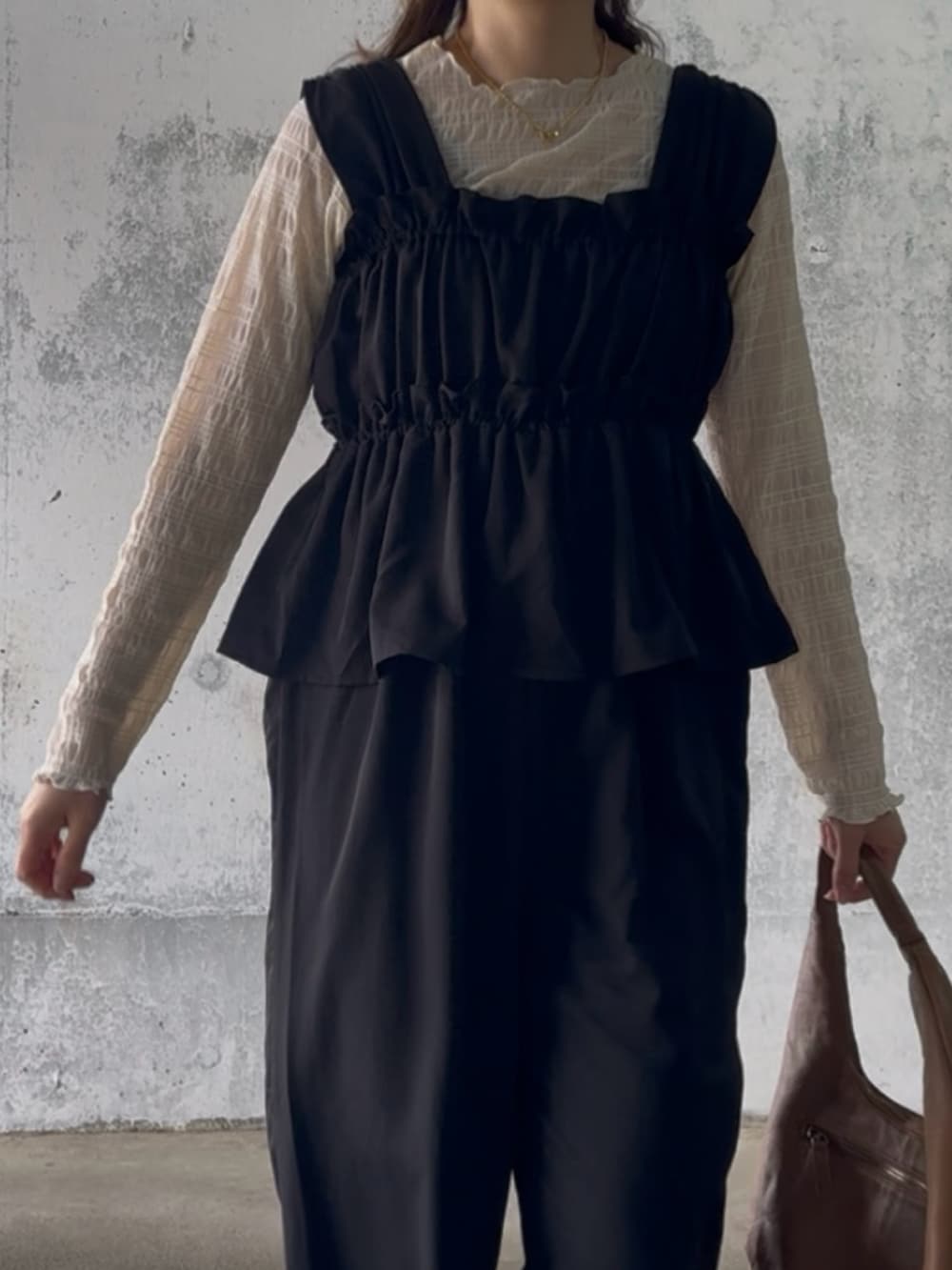 ベージュ系のTシャツ/カットソー、ブラック系のサロペット/オーバーオール、ベージュ系のスニーカーを着用したレディースの冬コーディネートの5枚目の写真