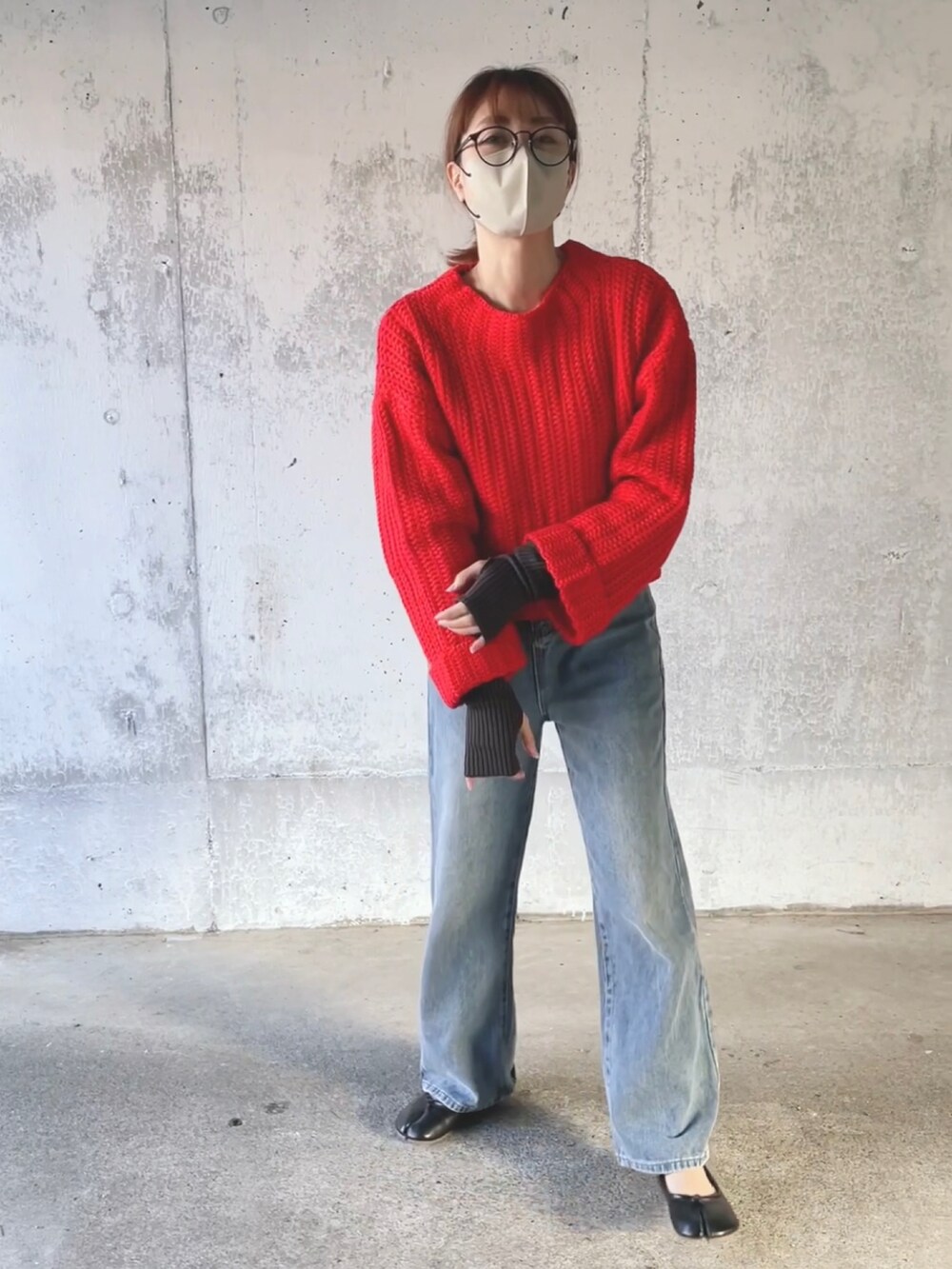 レッド系のニット/セーター、ブルー系のデニムパンツ、グレー系のアームカバーを着用したレディースの冬コーディネートの5枚目の写真