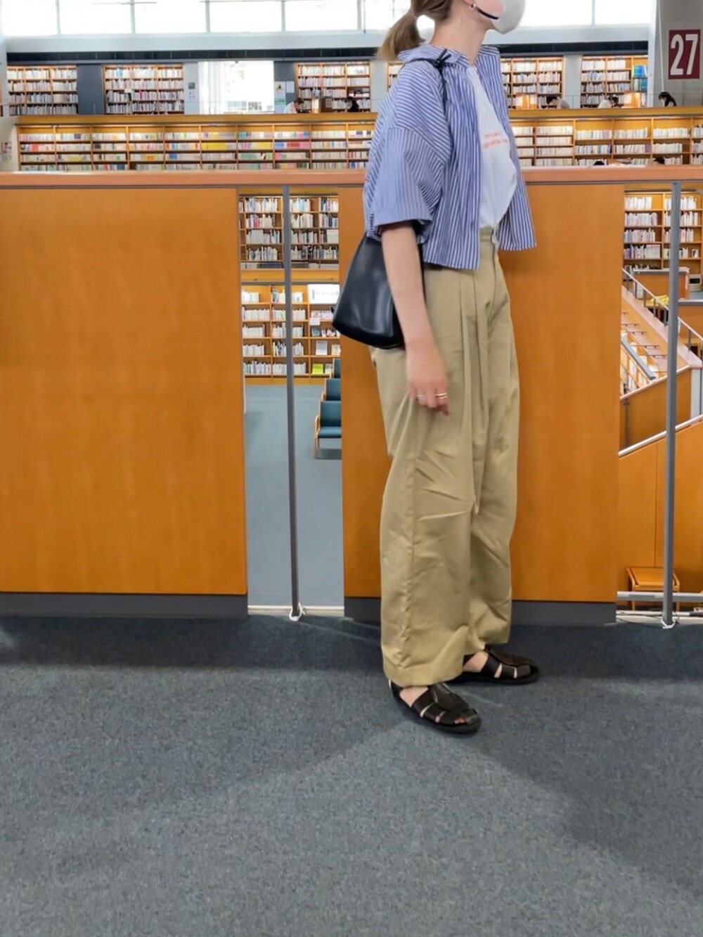 オレンジ系のTシャツ/カットソー、ベージュ系のチノパンツ、ブルー系のシャツ/ブラウスを着用したレディースの夏コーディネートの2枚目の写真