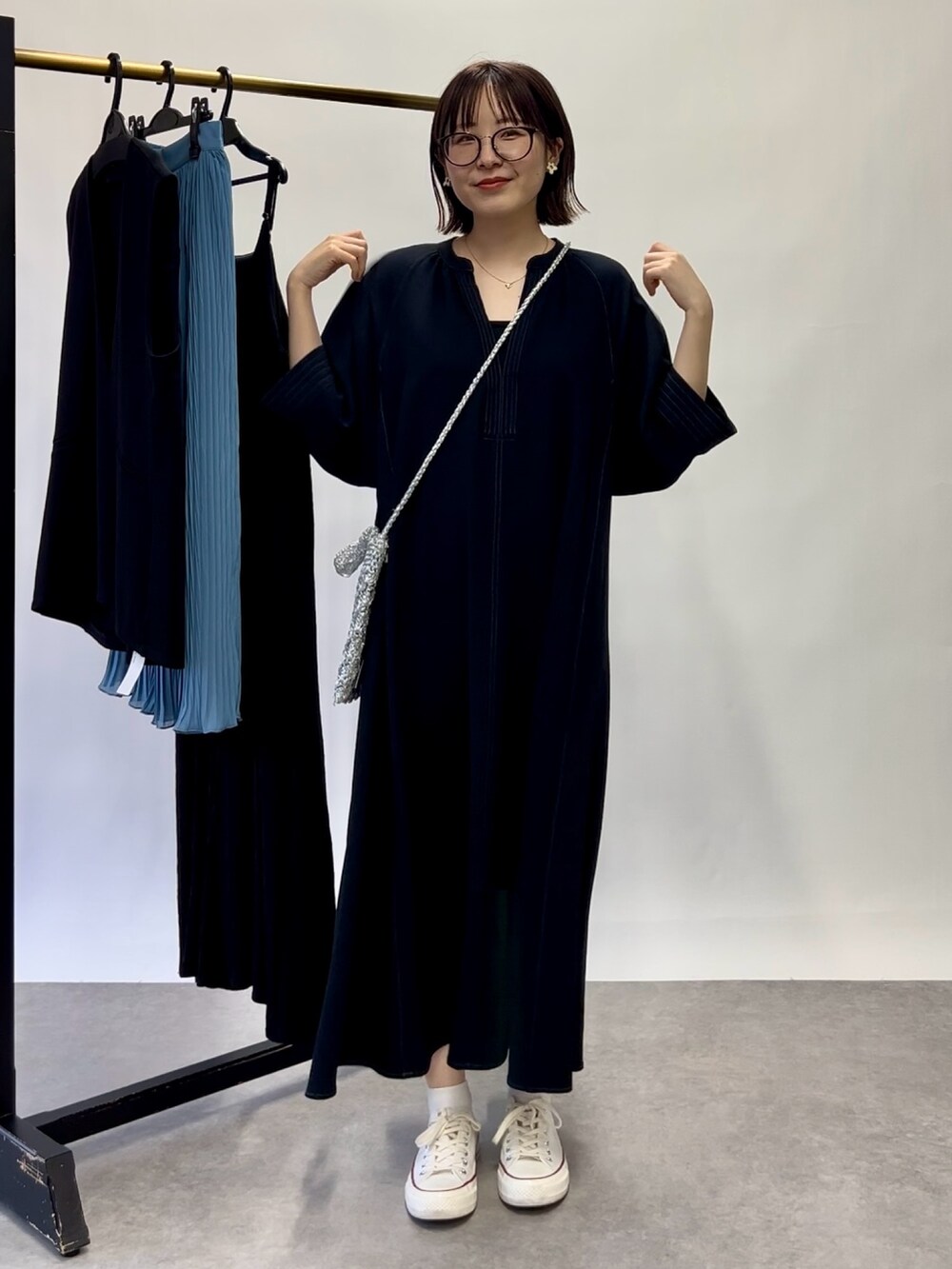 ブルー系のワンピース、シルバー系のショルダーバッグを着用したレディースの春コーディネートの2枚目の写真