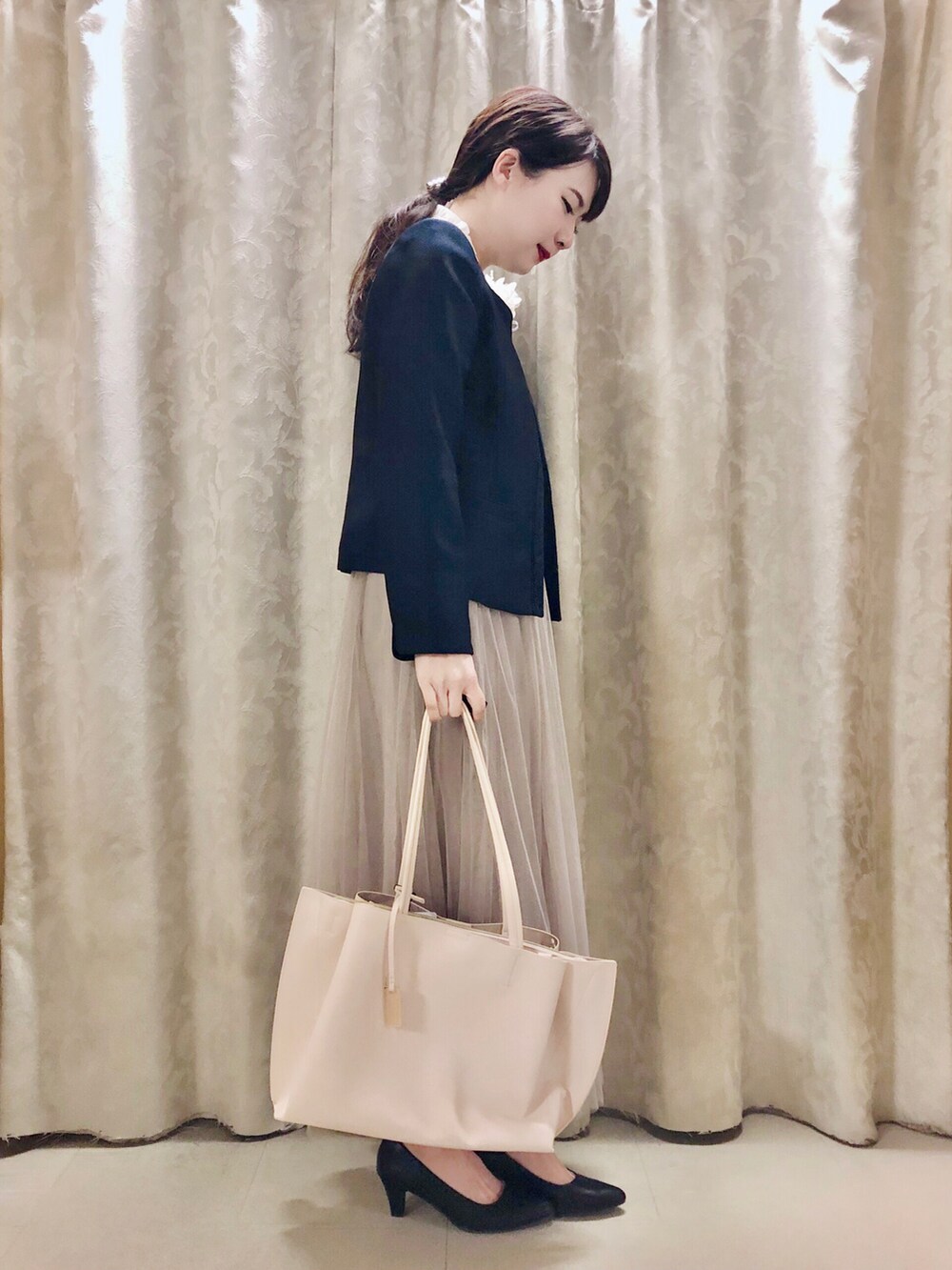 ホワイト系のトートバッグ、ブラック系のパンプス、ブルー系のノーカラージャケットを着用したレディースの冬コーディネートの2枚目の写真