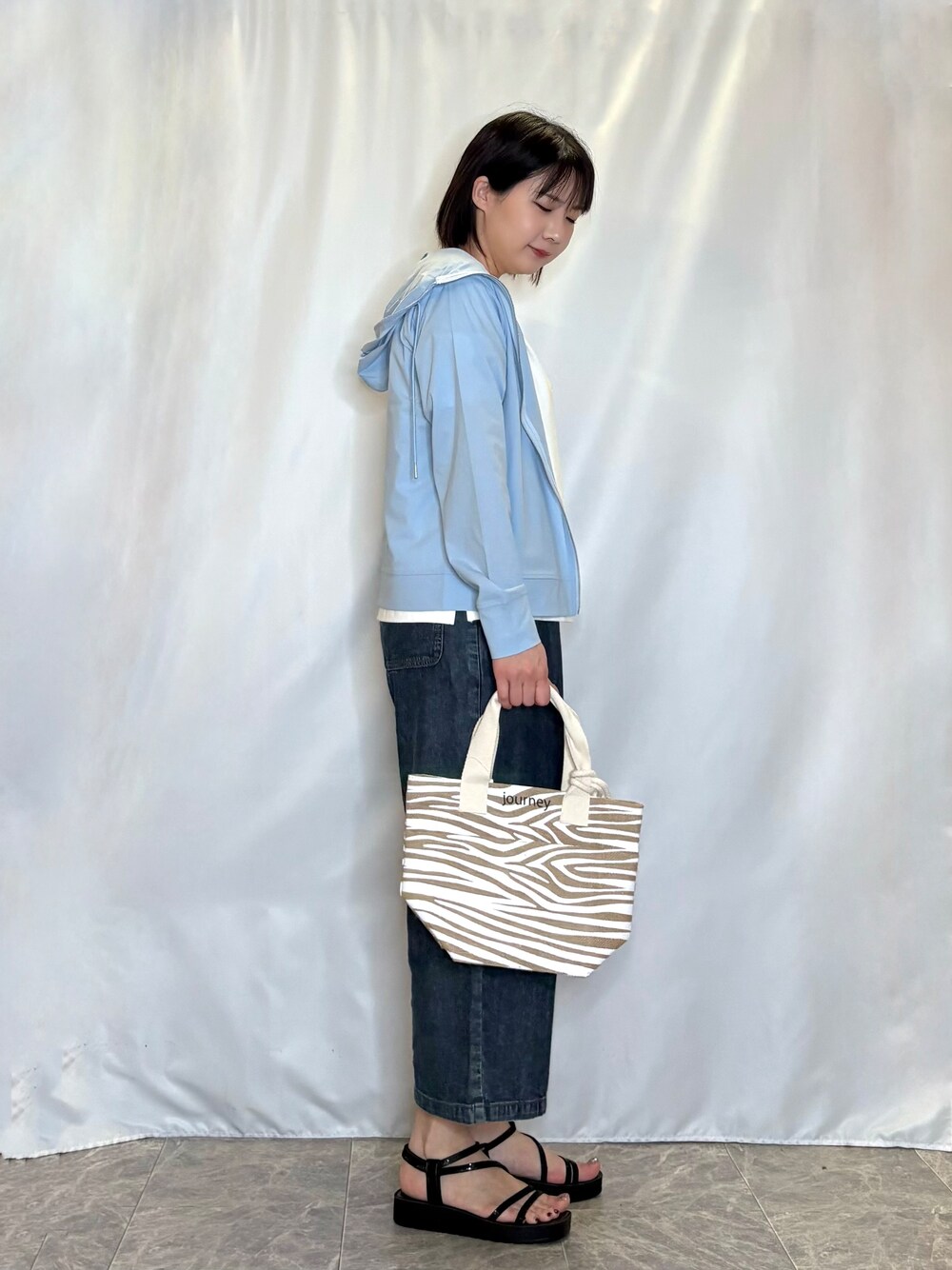 ブルー系のパーカー、ホワイト系のTシャツ/カットソー、ブルー系のデニムパンツを着用したレディースの春コーディネートの2枚目の写真