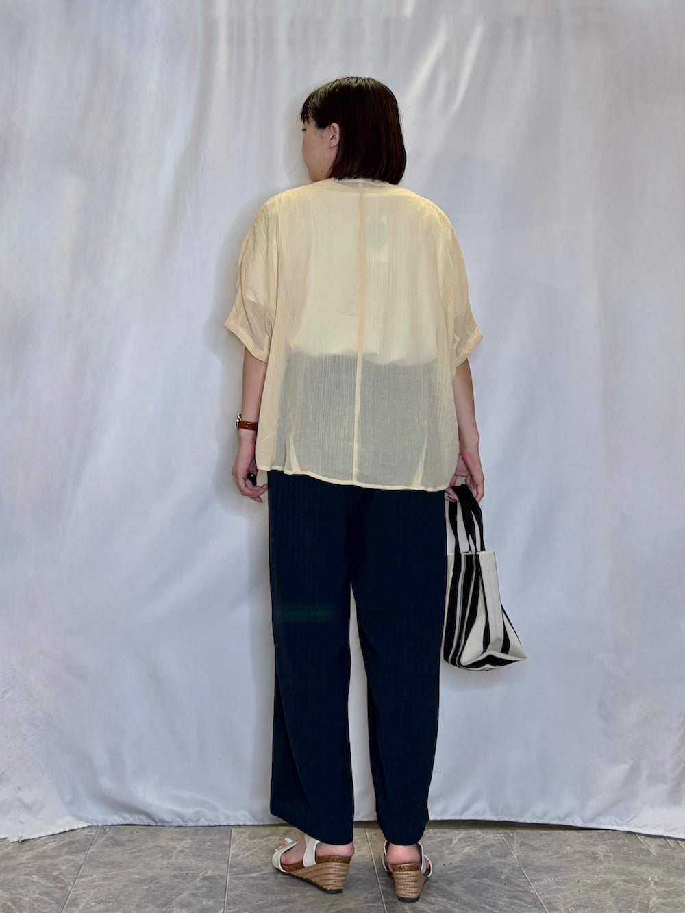 イエロー系のシャツ/ブラウス、ホワイト系のTシャツ/カットソー、ホワイト系のサンダルを着用したレディースの夏コーディネートの4枚目の写真